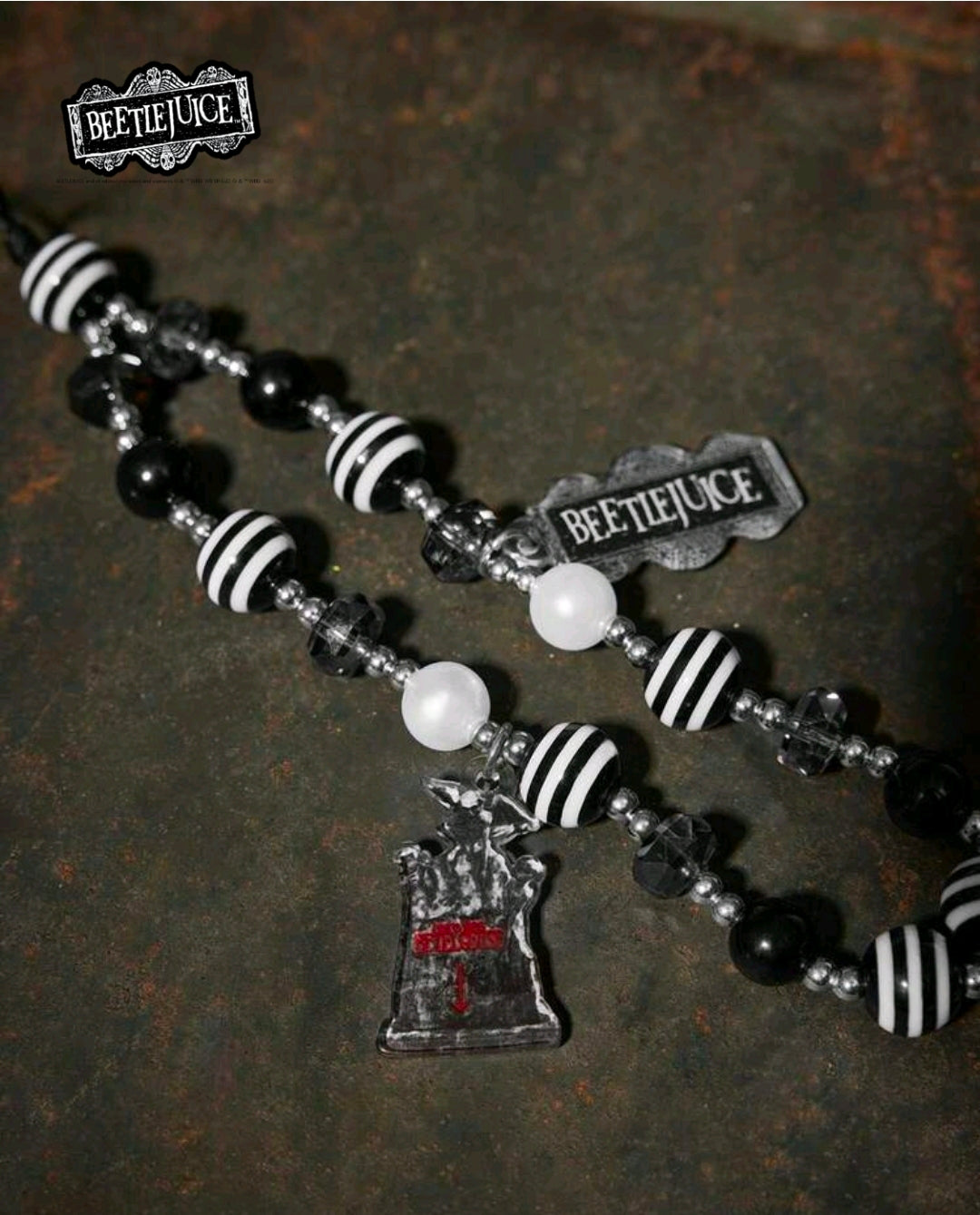 Beetlejuice beaded phone lanyard detail with hat charm, striped beads, and brand tags