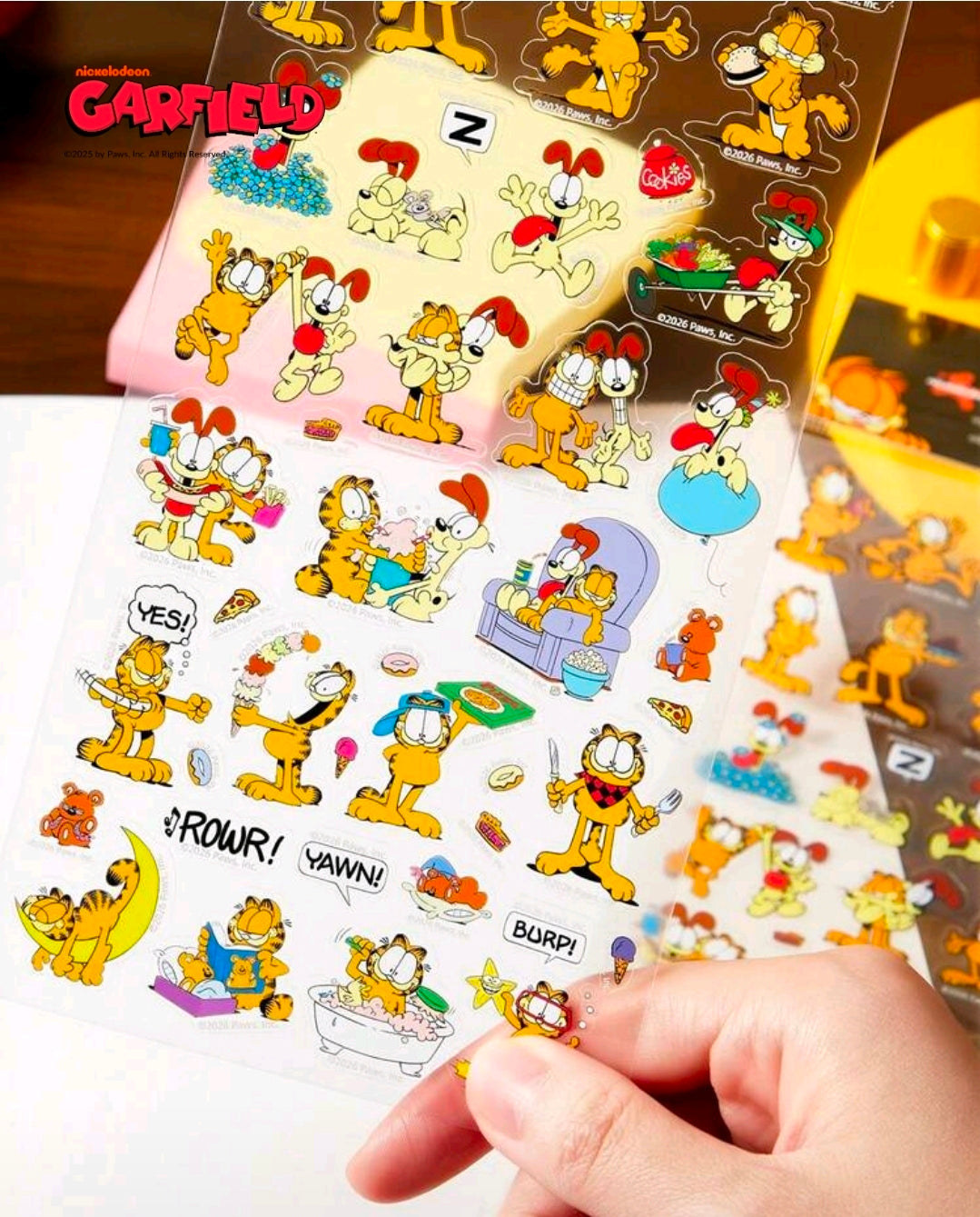 Garfield clear sticker sheet close-up with hand pressing small character stickers