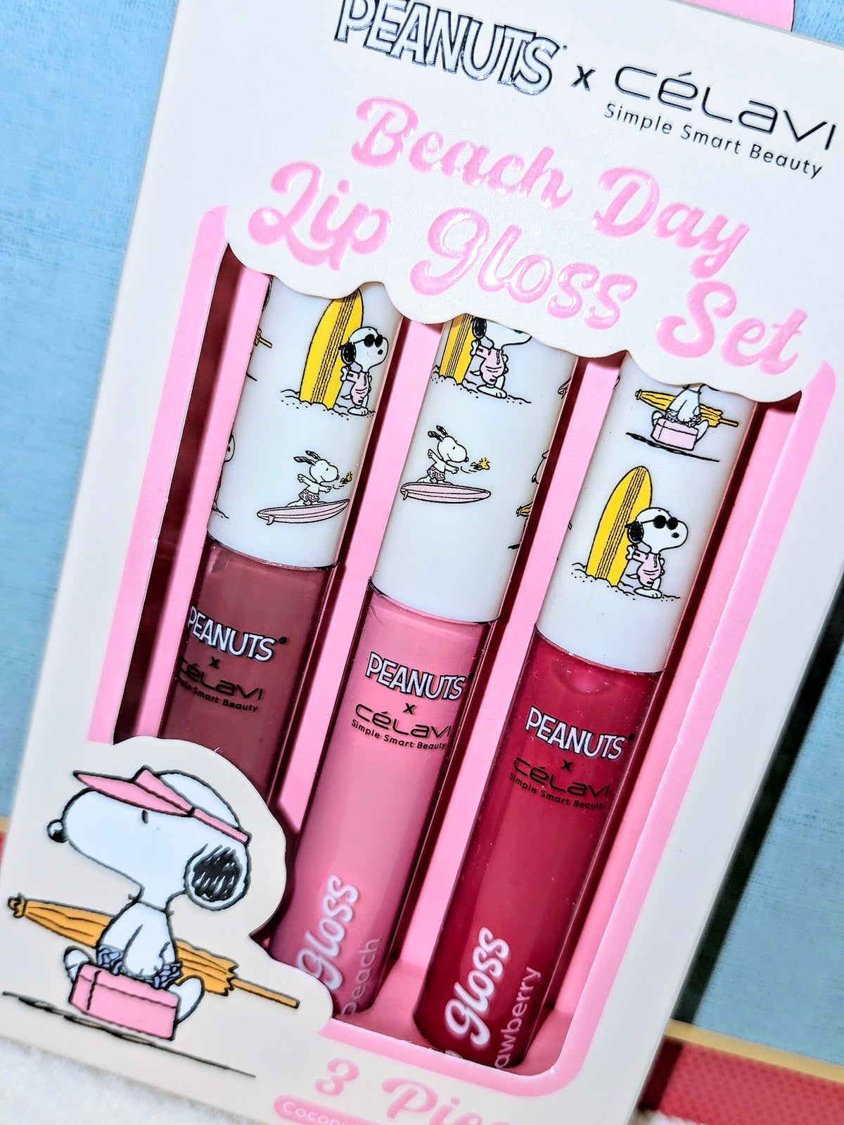 Retail box of three Snoopy lip gloss tubes labeled Beach Day Lip Gloss Set