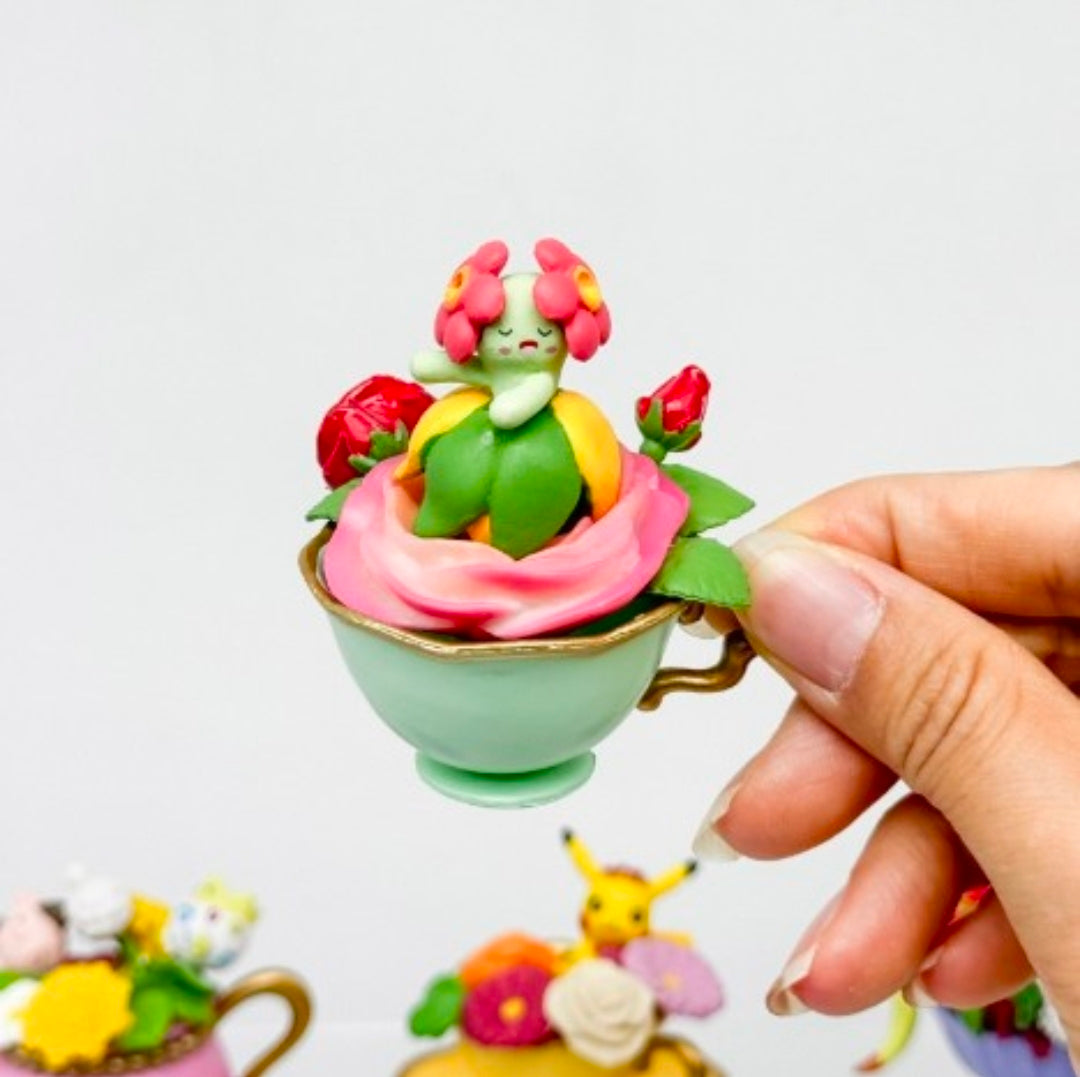 Green frog mini figure in mint cup with pink base and red flower details