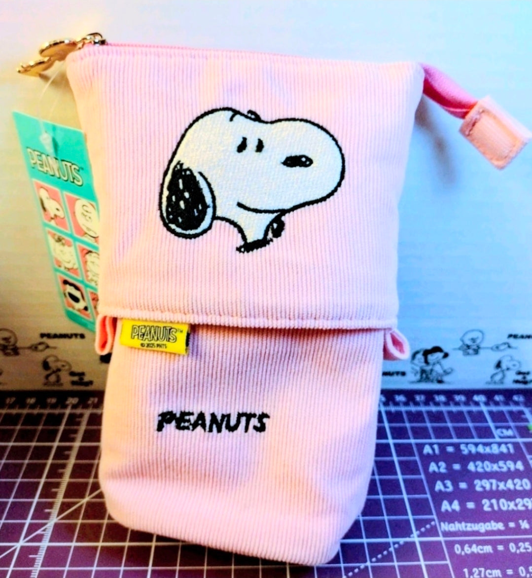 Pink corduroy pop-up pencil case with Snoopy embroidery and PEANUTS text, standing.