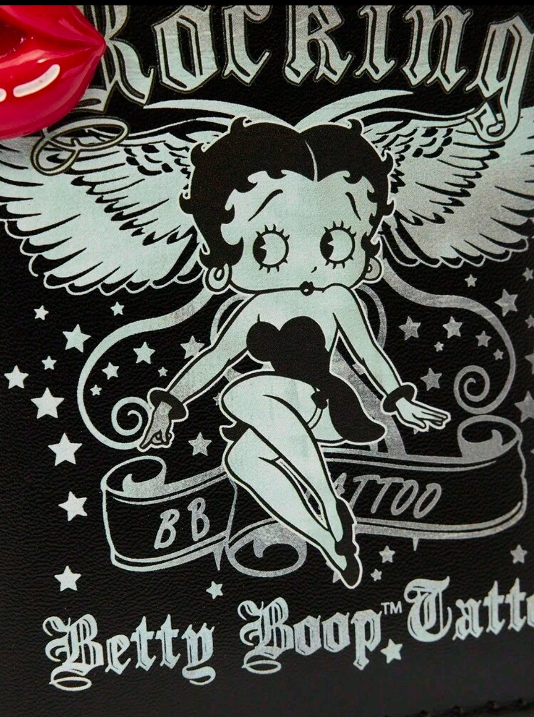Black coin purse close-up with Betty Boop tattoo artwork and metal zipper teeth