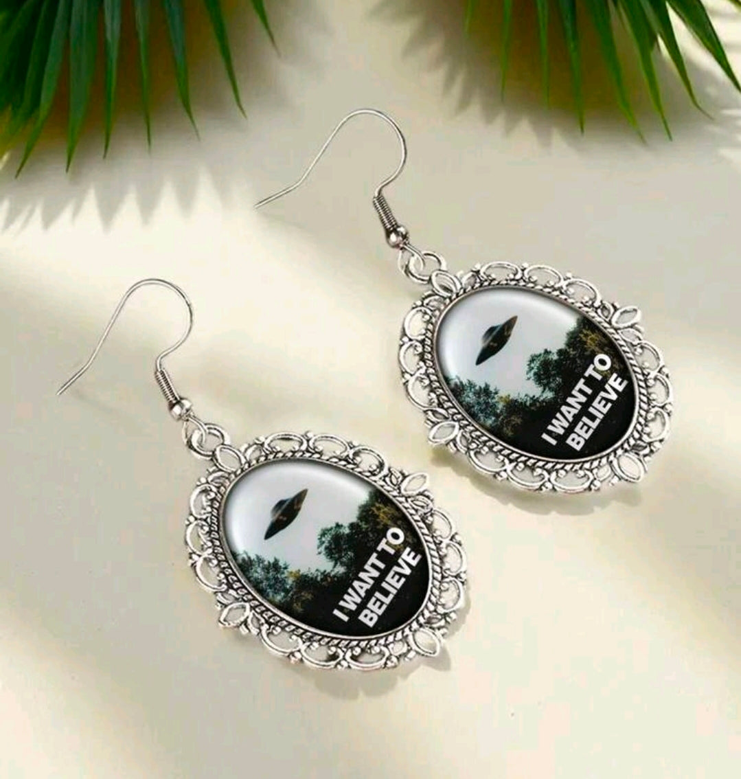 Pair of silver oval dangle earrings with UFO scene and I Want to Believe text