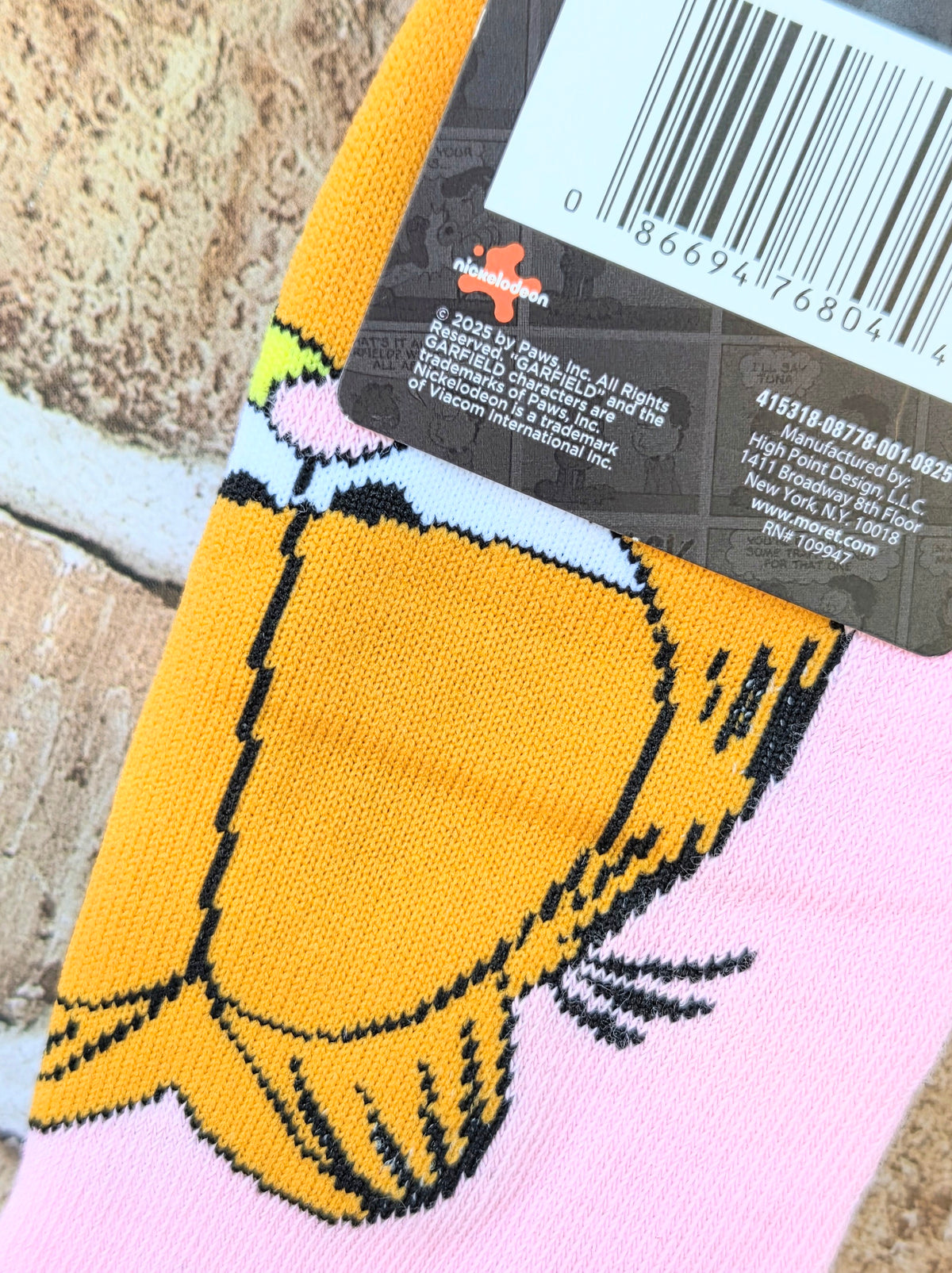 Orange and pink Garfield socks with close-up of smiling cat face and bold black outlines.
