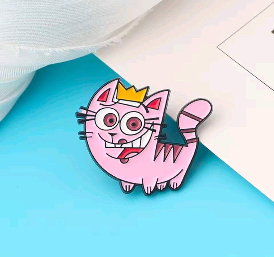 Close-up of a pink enamel cat character pin with a crown and raised paw