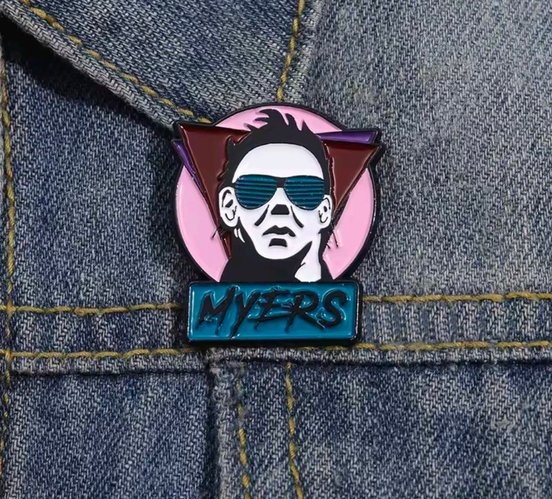 Enamel pin showing Michael Myers face with blue sunglasses and "MYERS" lettering