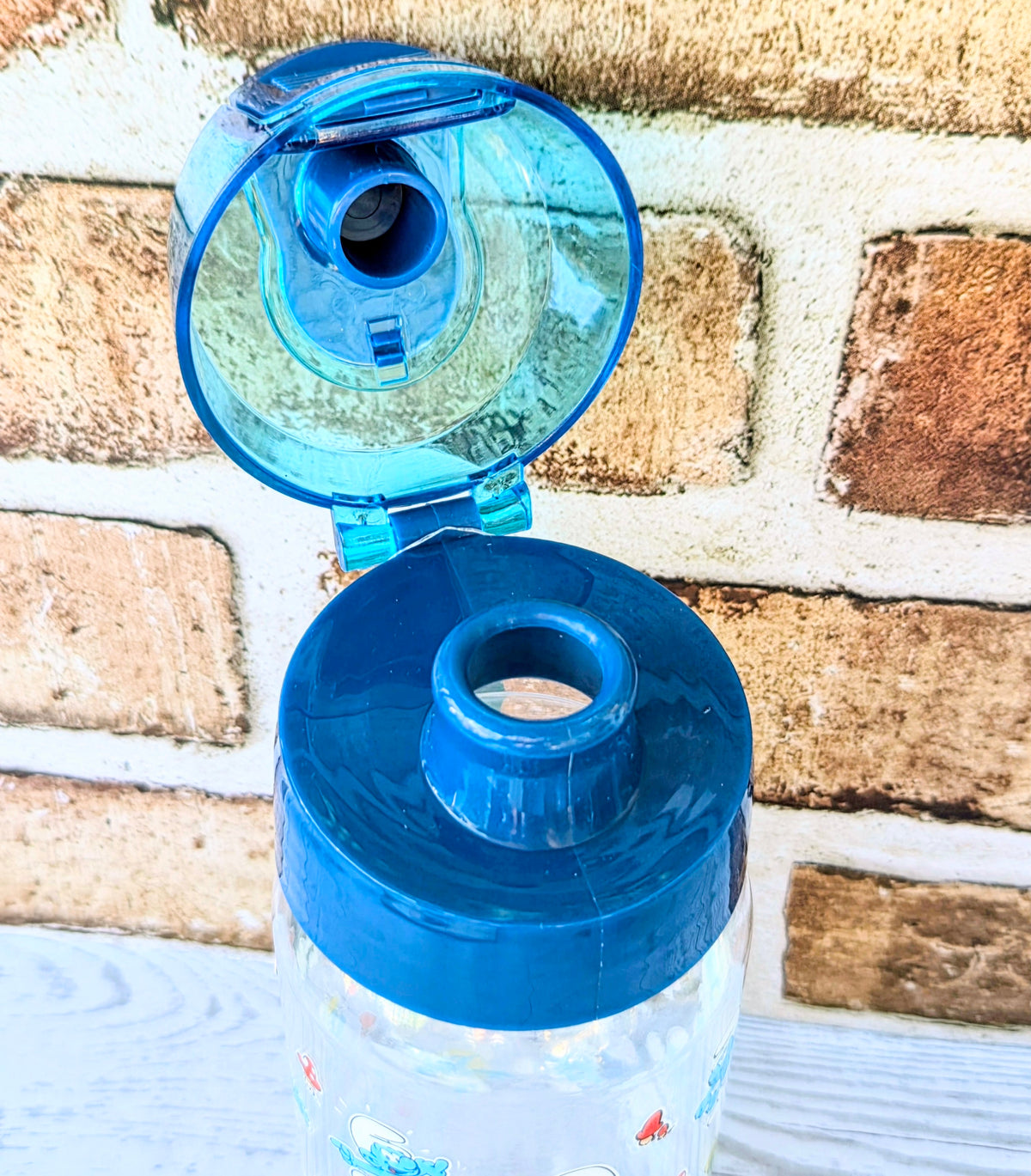 Blue translucent water bottle with flip-open lid and drinking spout