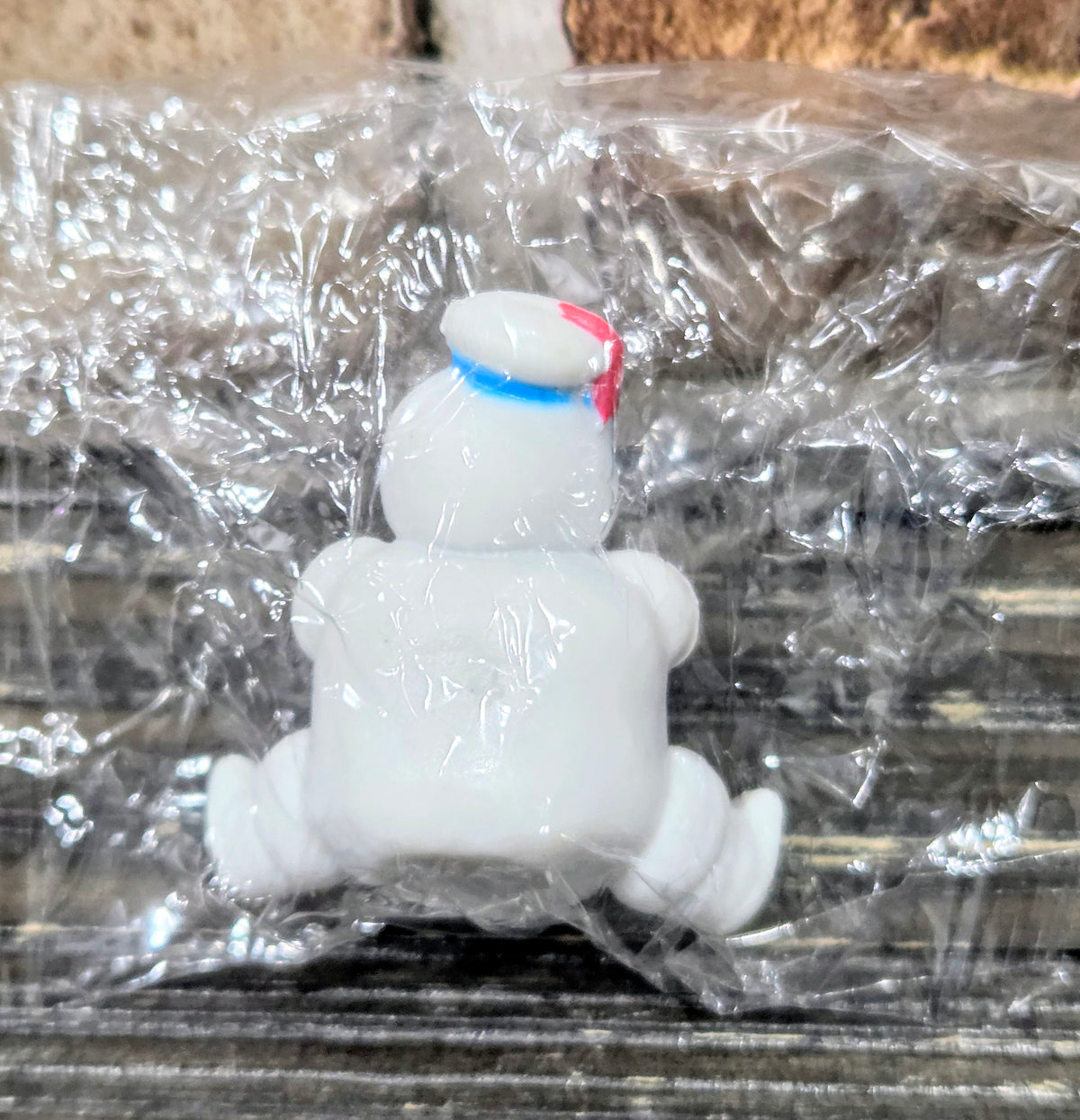 White mini Puft figure from behind, red-and-blue striped hat on top.
