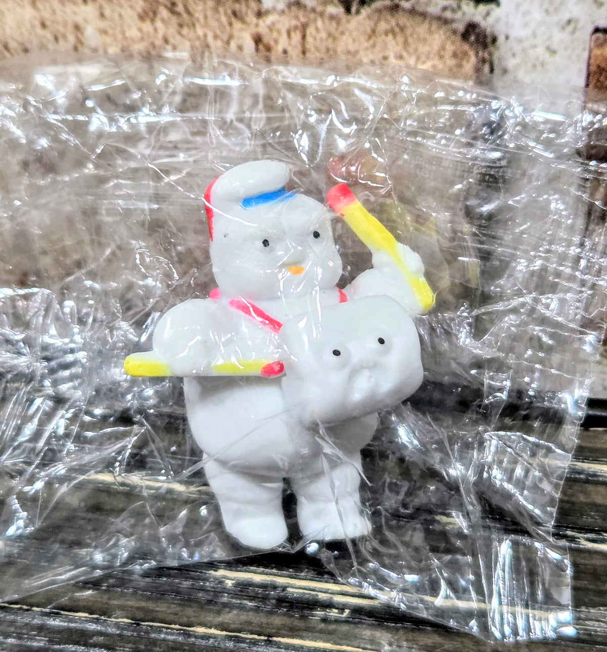 Two white Mini-Puft ghost figures holding yellow matchstick accessories, in plastic bag