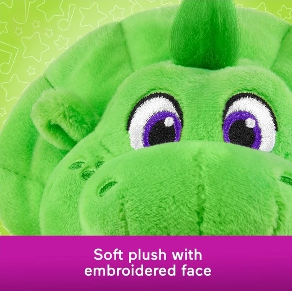 Green plush dinosaur face with purple eyes and shaggy top tuft, close-up detail