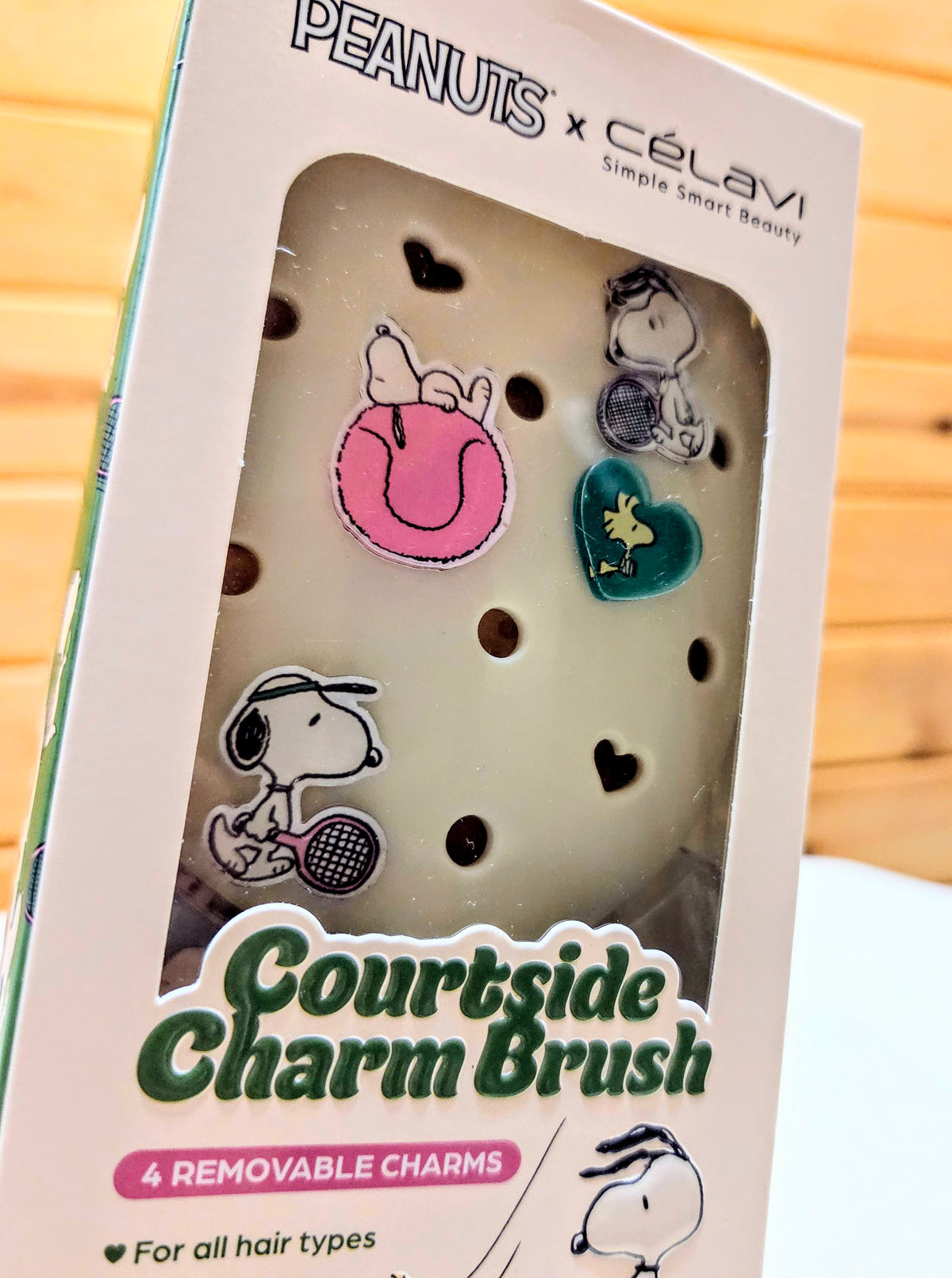 Snoopy-themed charm hairbrush box with four charms behind clear window