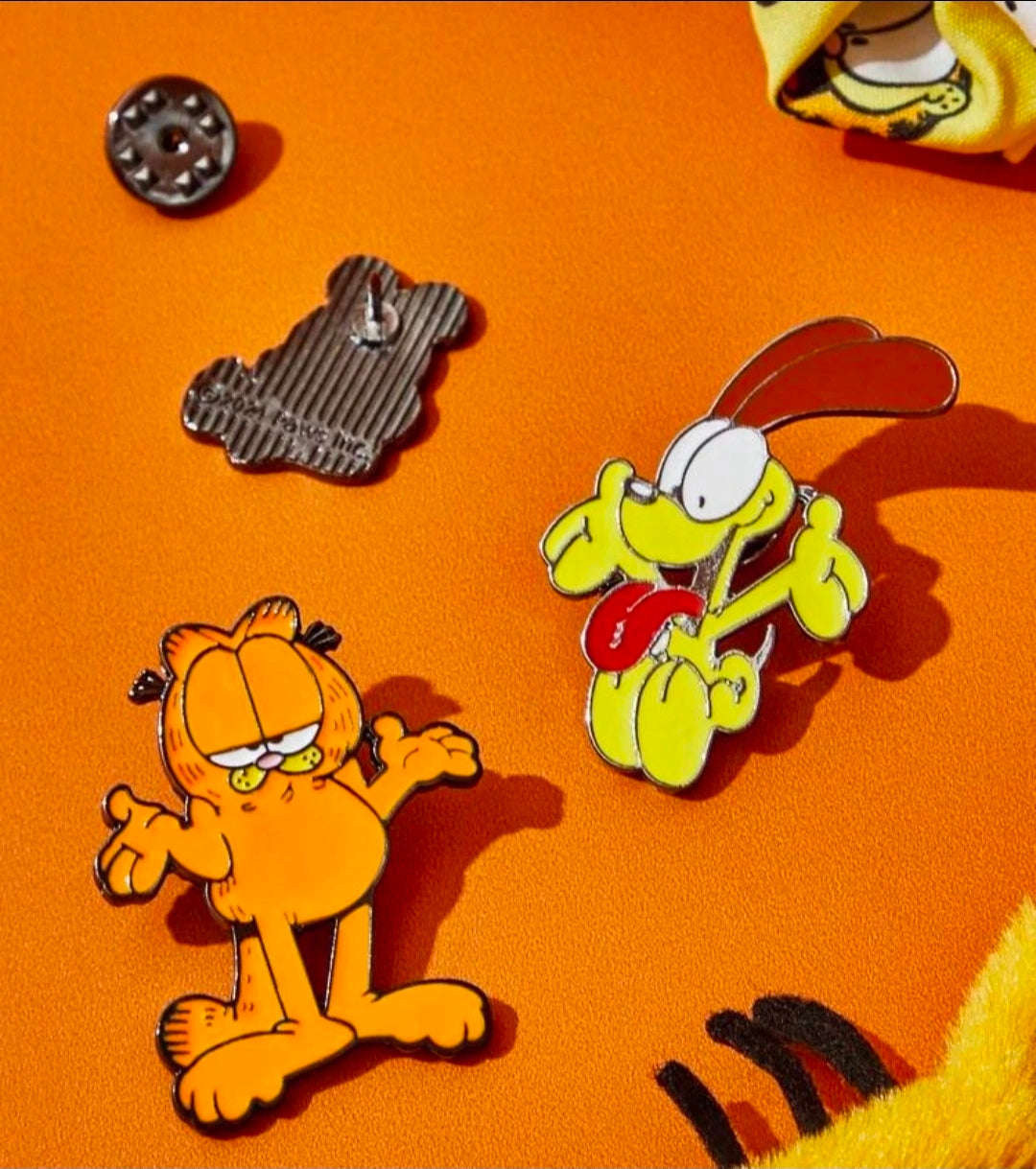 Three enamel character pins with metal pin backs: orange cat, yellow dog, brown bear