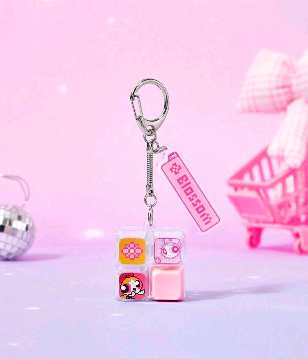 Pink cube fidget keychain with character-face charms and metal keyring