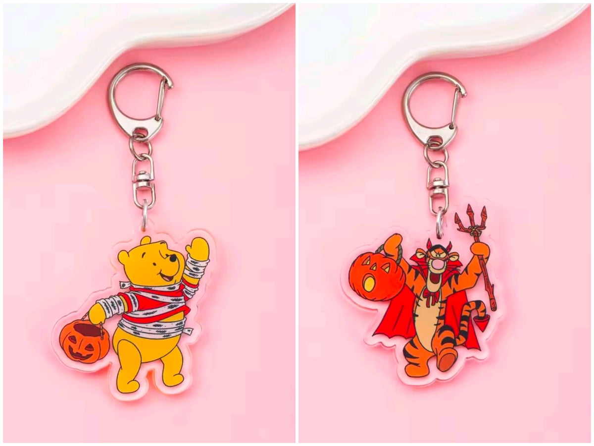 Acrylic Halloween keychain with carabiner; Pooh dressed as a striped cowboy holding a pumpkin bucket.
