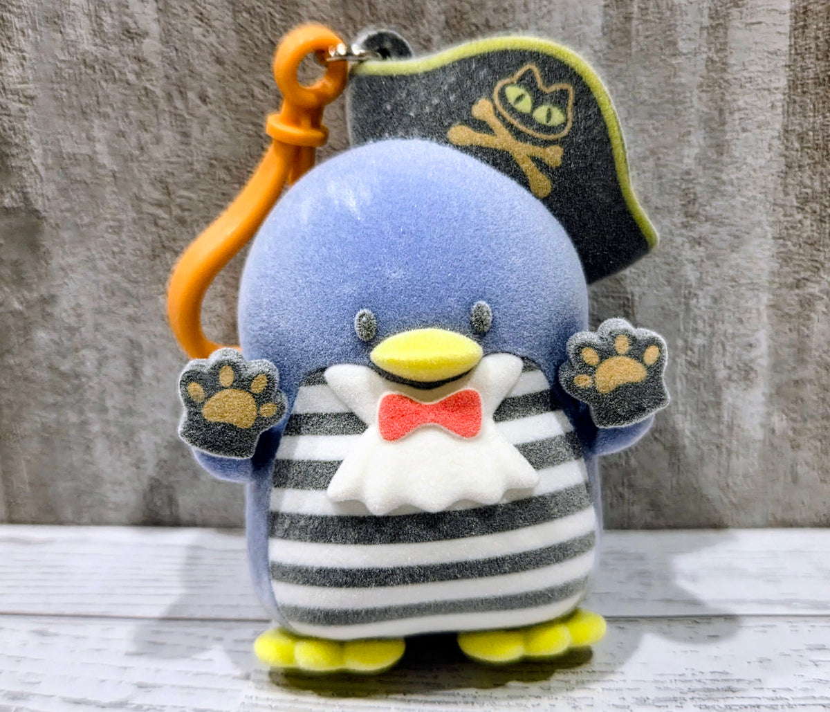 Front view of blue Tuxedo Sam plush bag clip with pirate hat, paw patches, bow