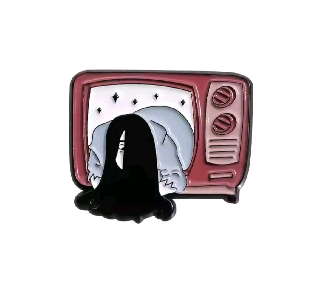 Enamel TV screen pin with a black hooded figure on a pink TV frame.