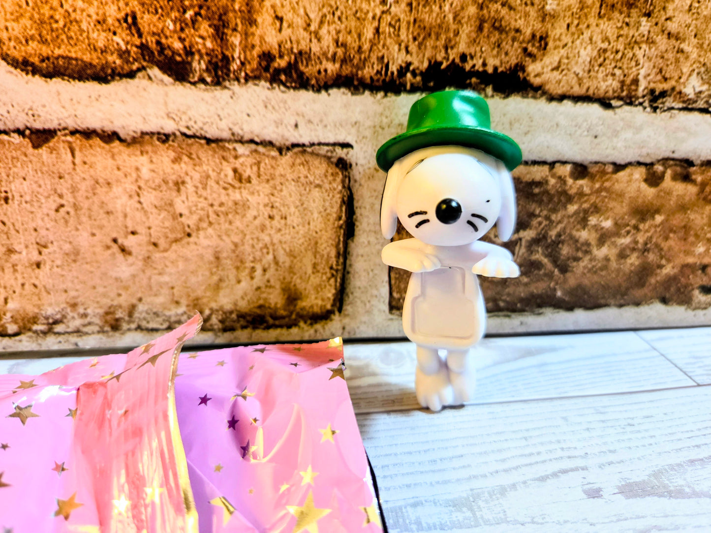 White mini figure with green top hat and whiskered face, standing pose