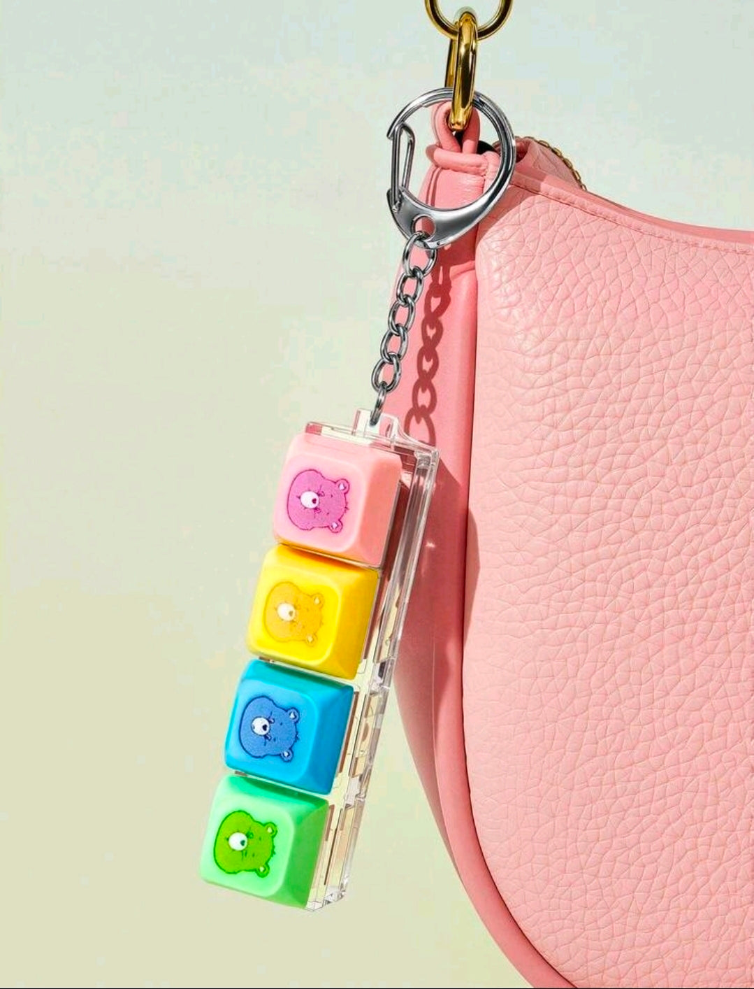 Keychain fidget attached to a pink bag with clear case and multicolor bear blocks