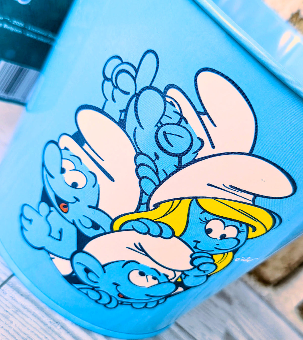 Blue bucket with cartoon character crowd graphic and yellow hat illustration