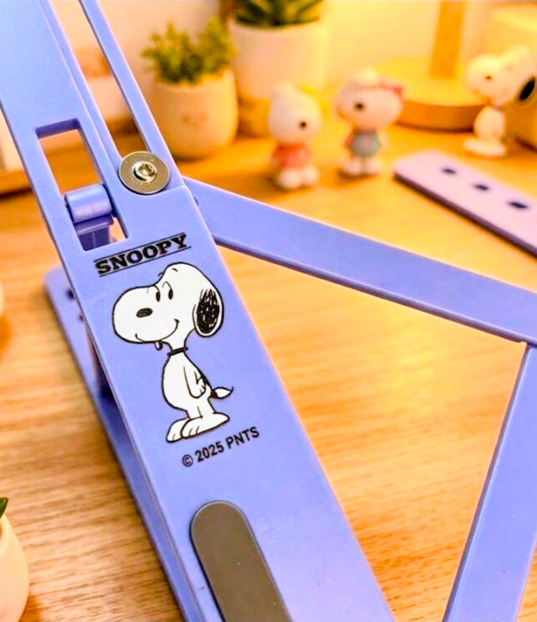 Purple foldable laptop stand base with Snoopy decal on the side