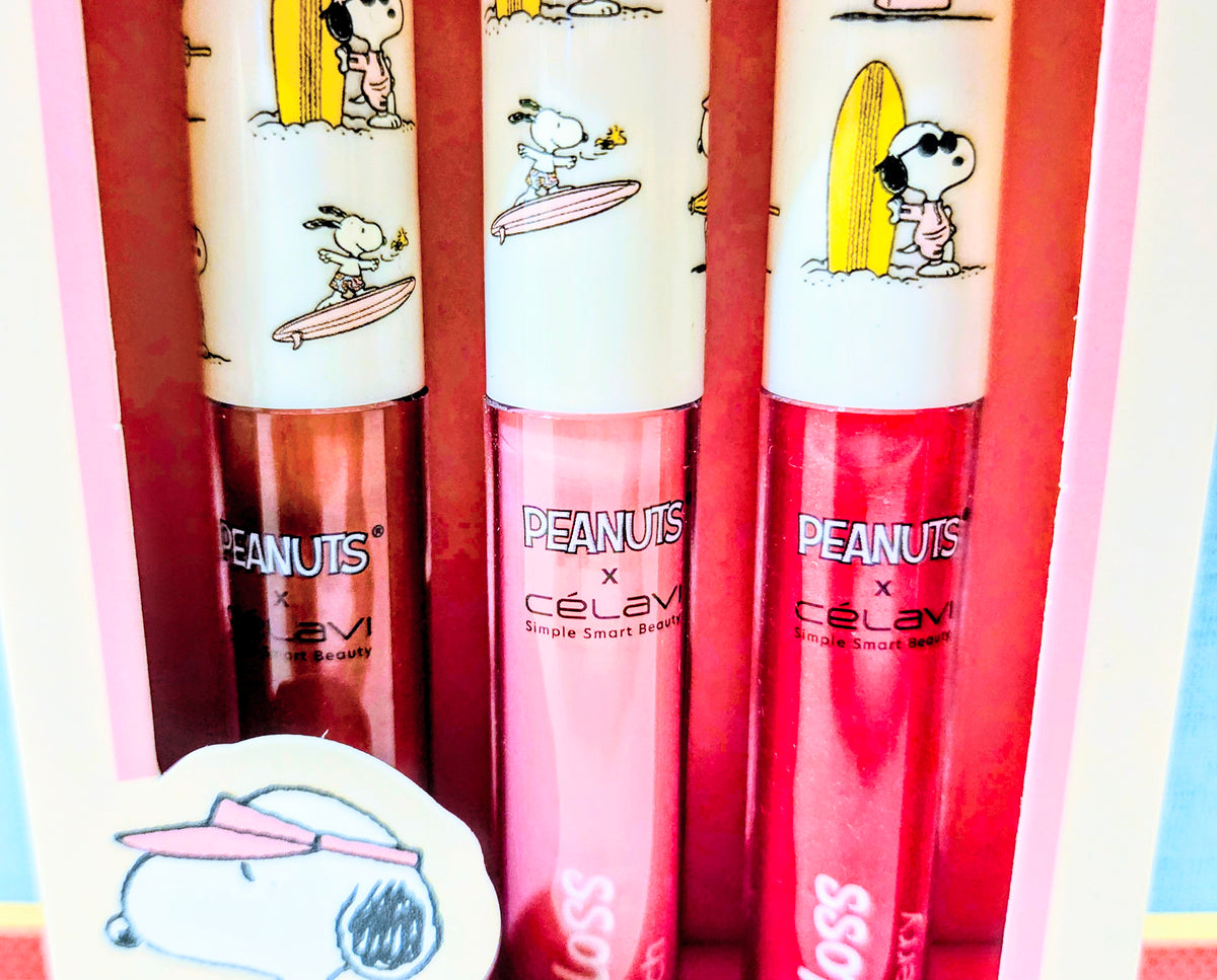 Lip gloss set with three Snoopy-themed tubes, pink and red shades with caps