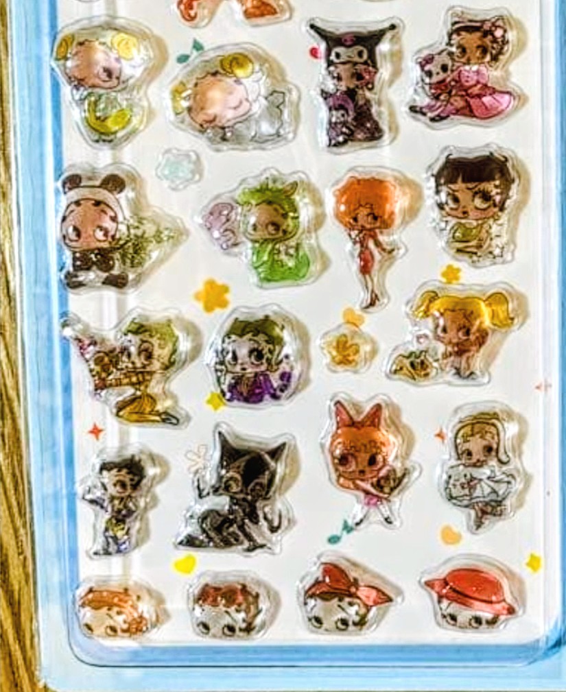 Close-up sticker sheet showing metallic animal character decals on clear backing