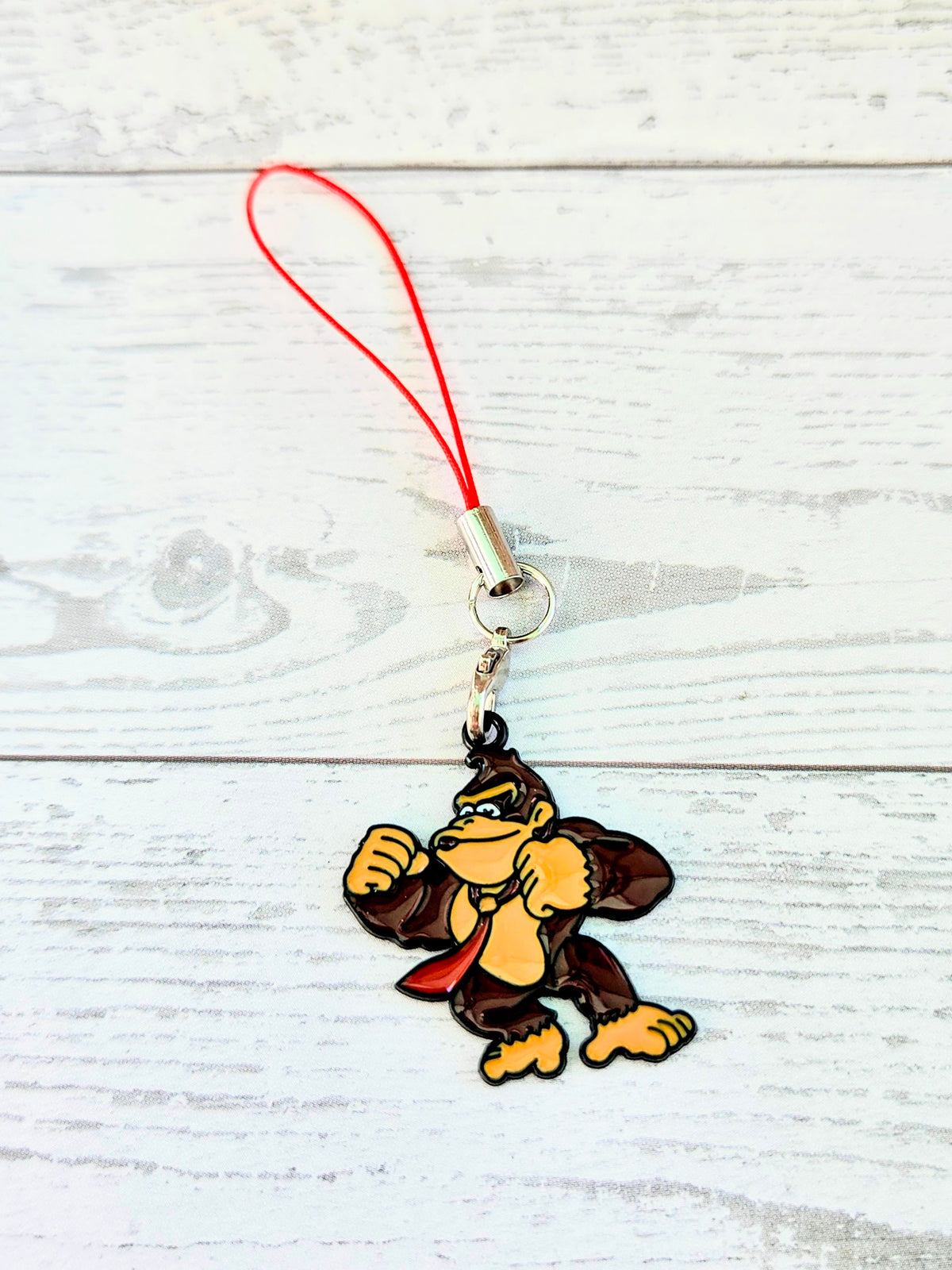 Red cord phone charm wrist strap with small Donkey Kong enamel character charm