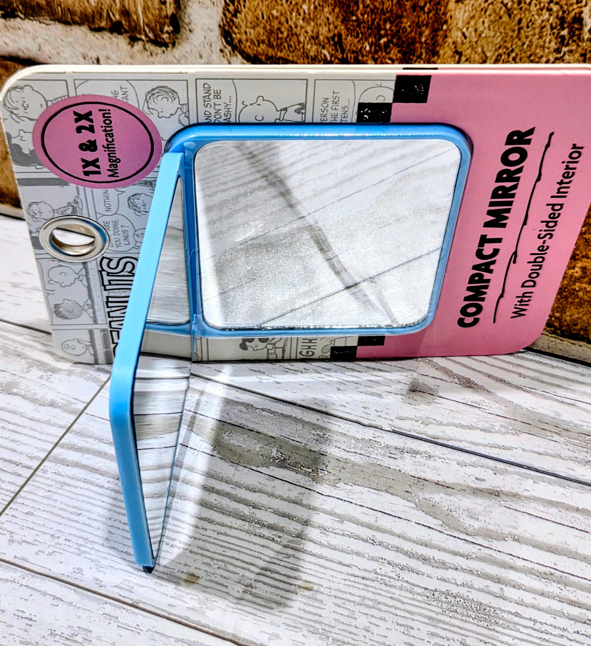 Snoopy compact mirror with blue frame and pink backing, suction grip design