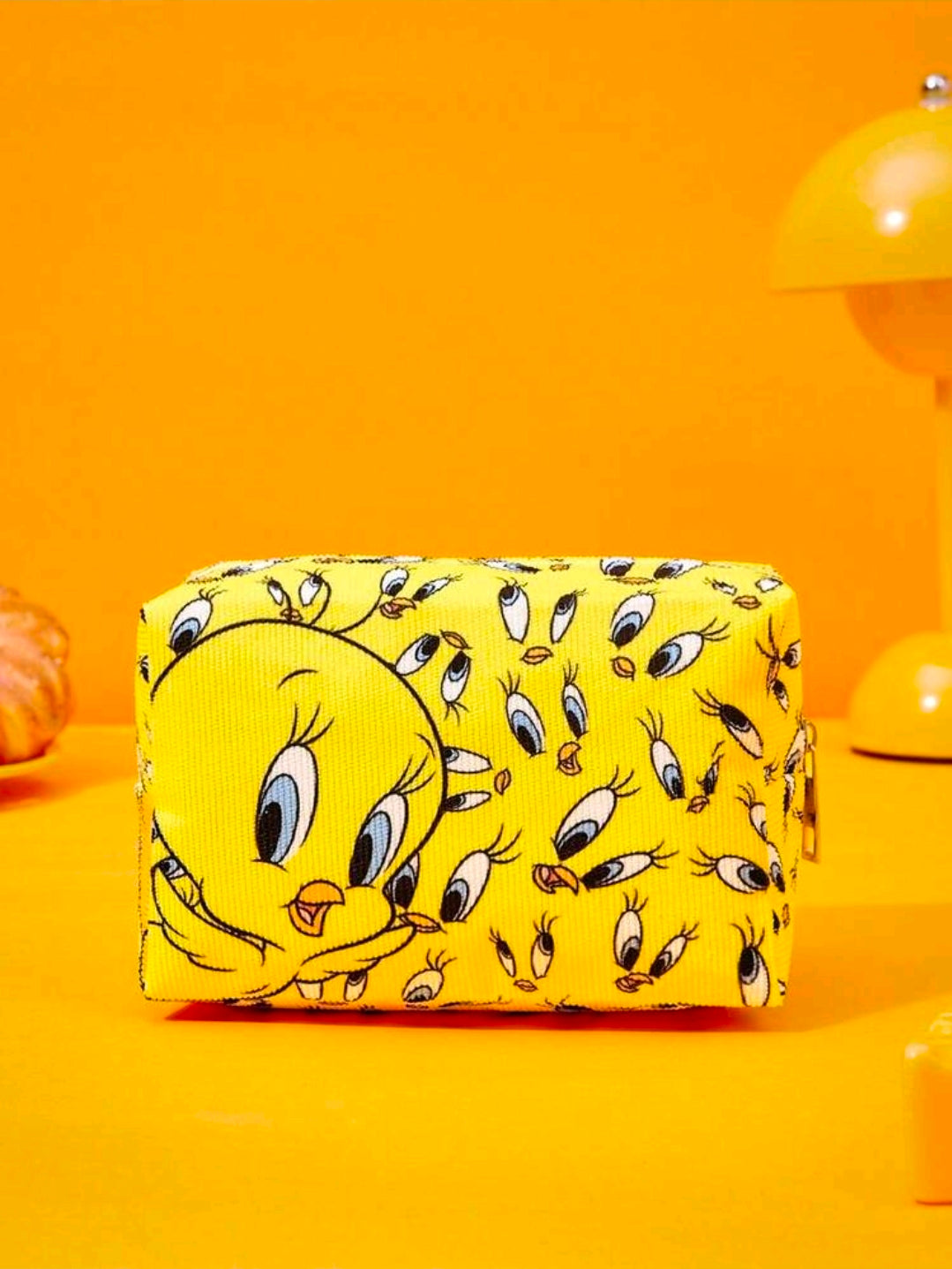 Yellow makeup pouch featuring a large Tweety face illustration on print