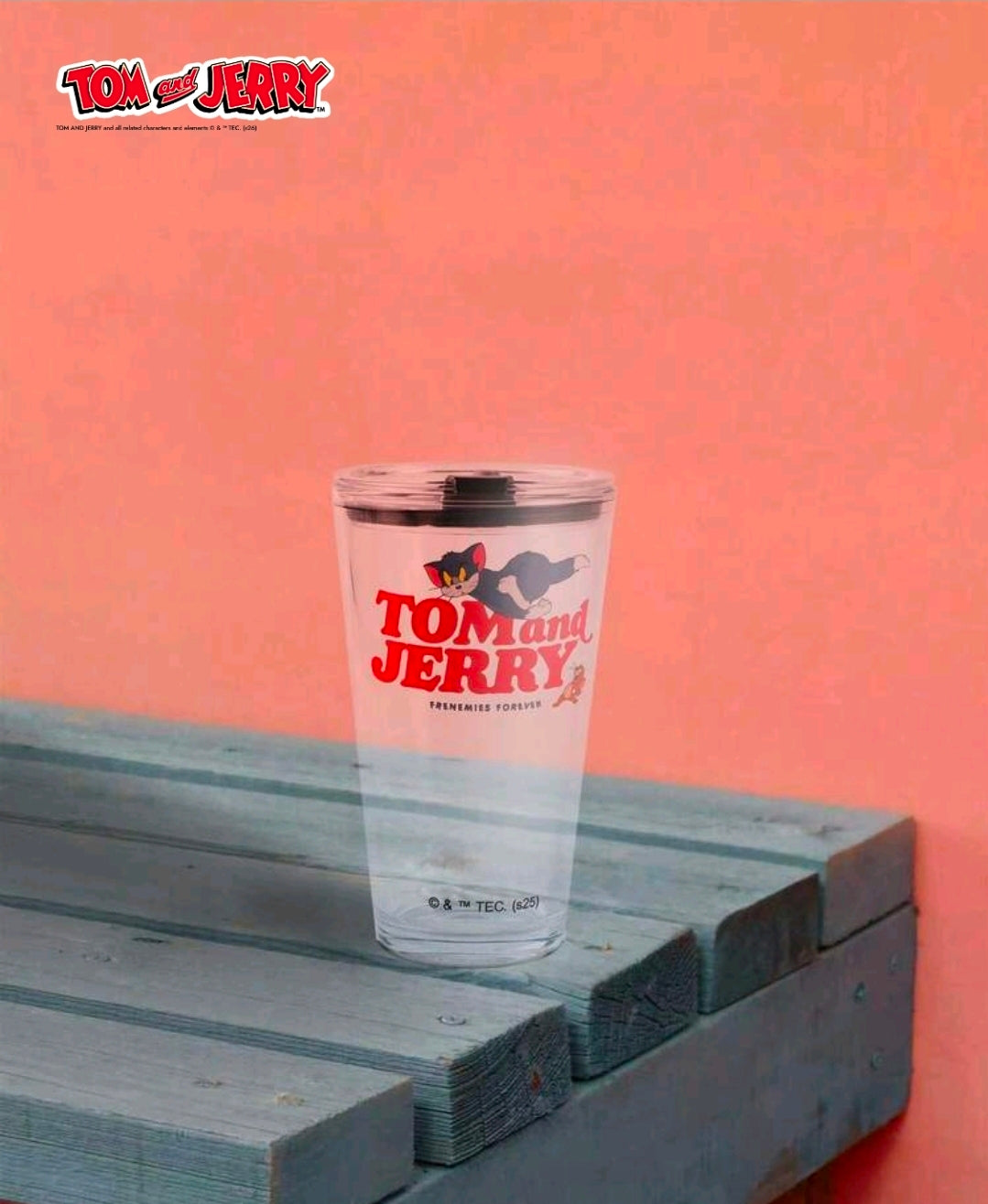 Clear tumbler with Tom and Jerry graphic and black lid, close side view