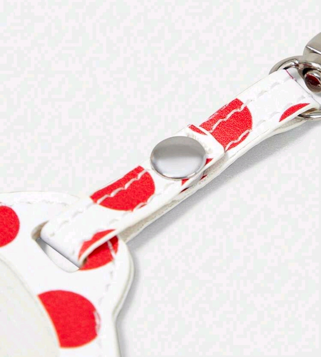 White fabric keychain strap with red polka dots and a silver metal loop ring