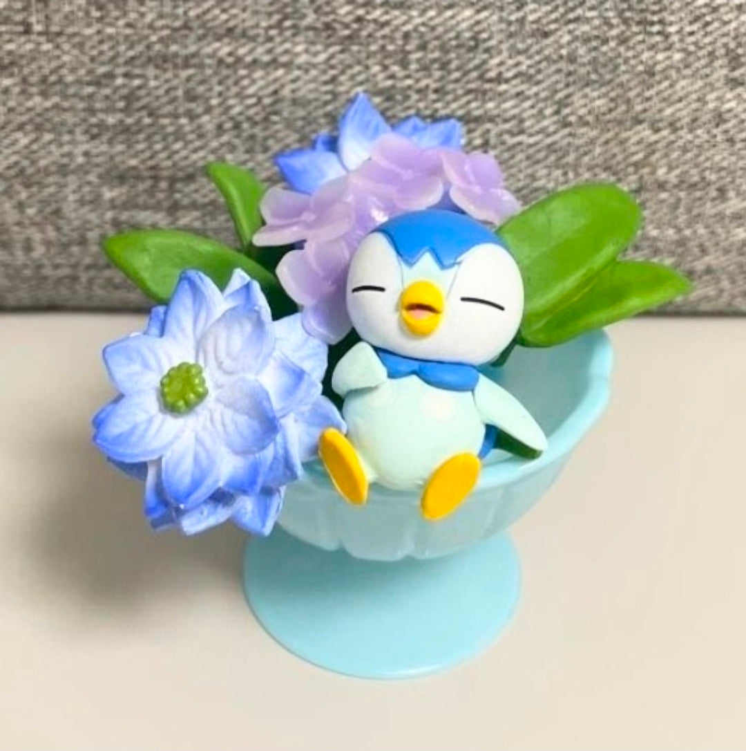 Light blue cup mini figure with penguin and blue flower bouquet with green leaves