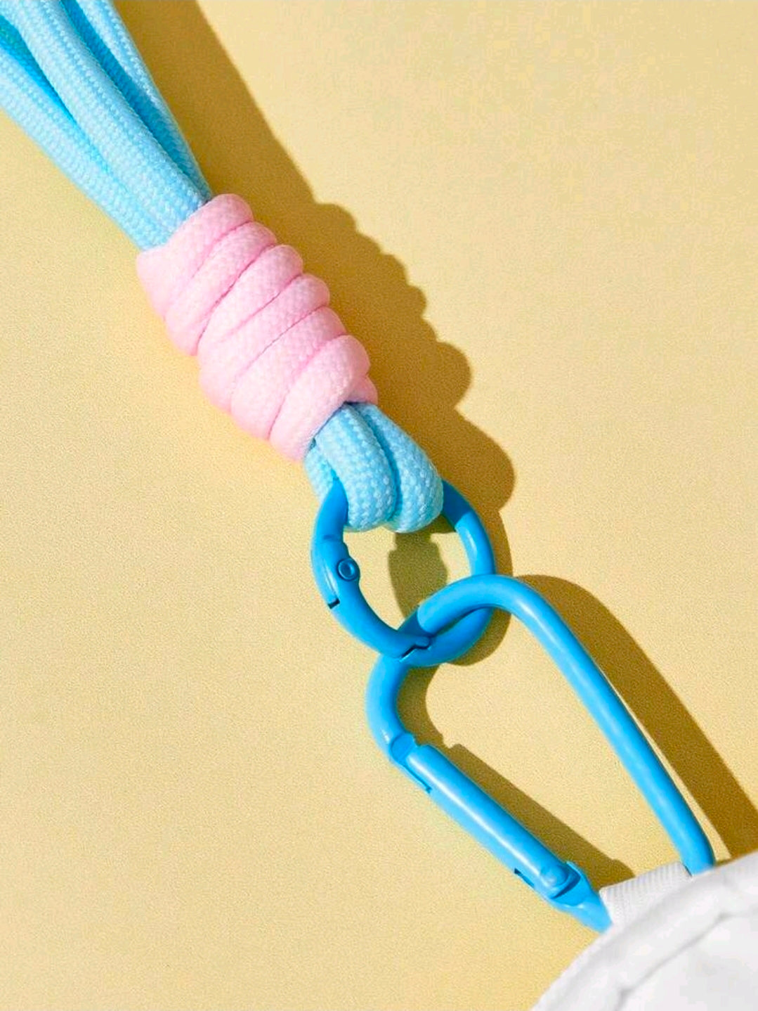 Close-up of blue lanyard clasp connected to a mini zip coin purse