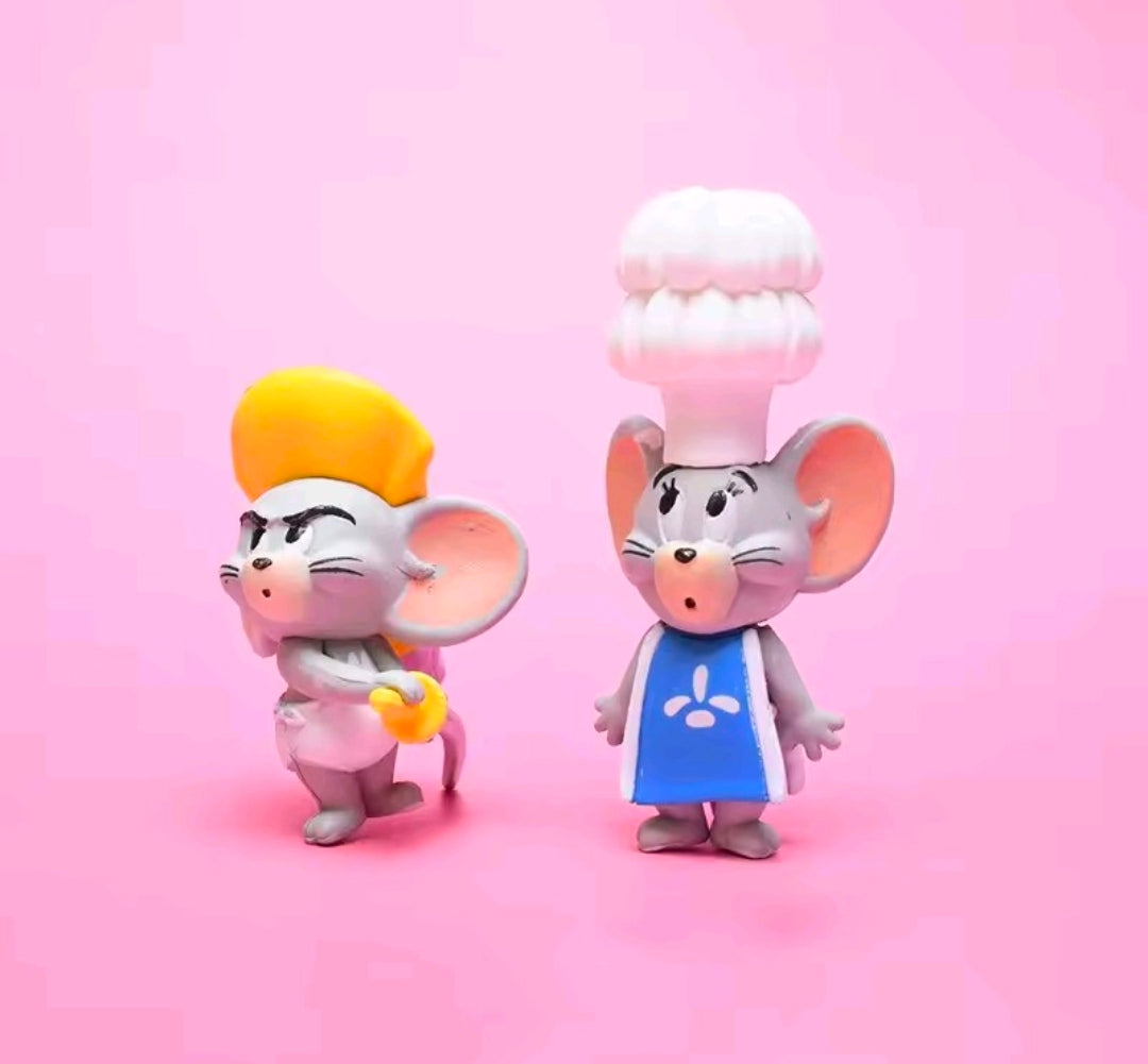 Two chef-themed Tom & Jerry mini figurines: yellow-hatted cat and pink chef in blue