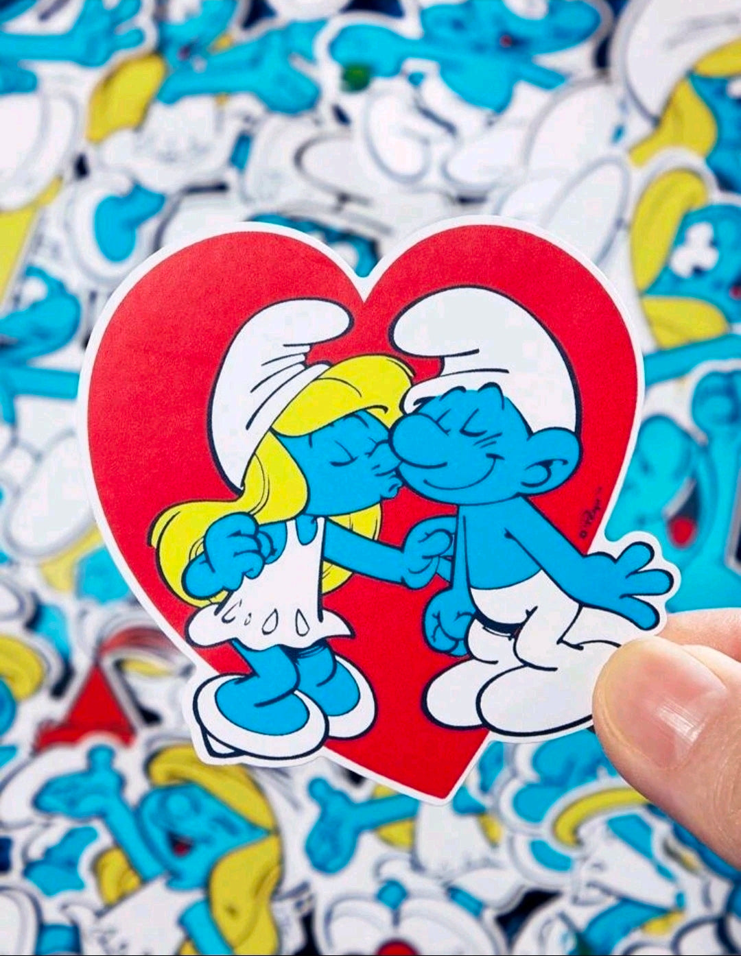 Heart-shaped Smurfs vinyl decal with two Smurfs kissing, held in hand