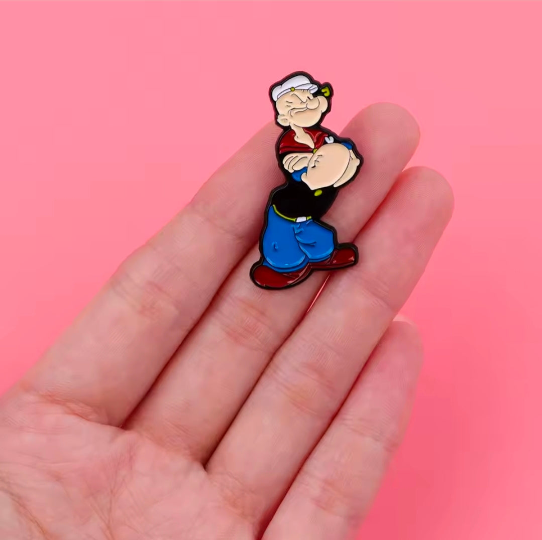 Cartoon sailor enamel lapel pin, standing pose with red shirt and blue overalls.