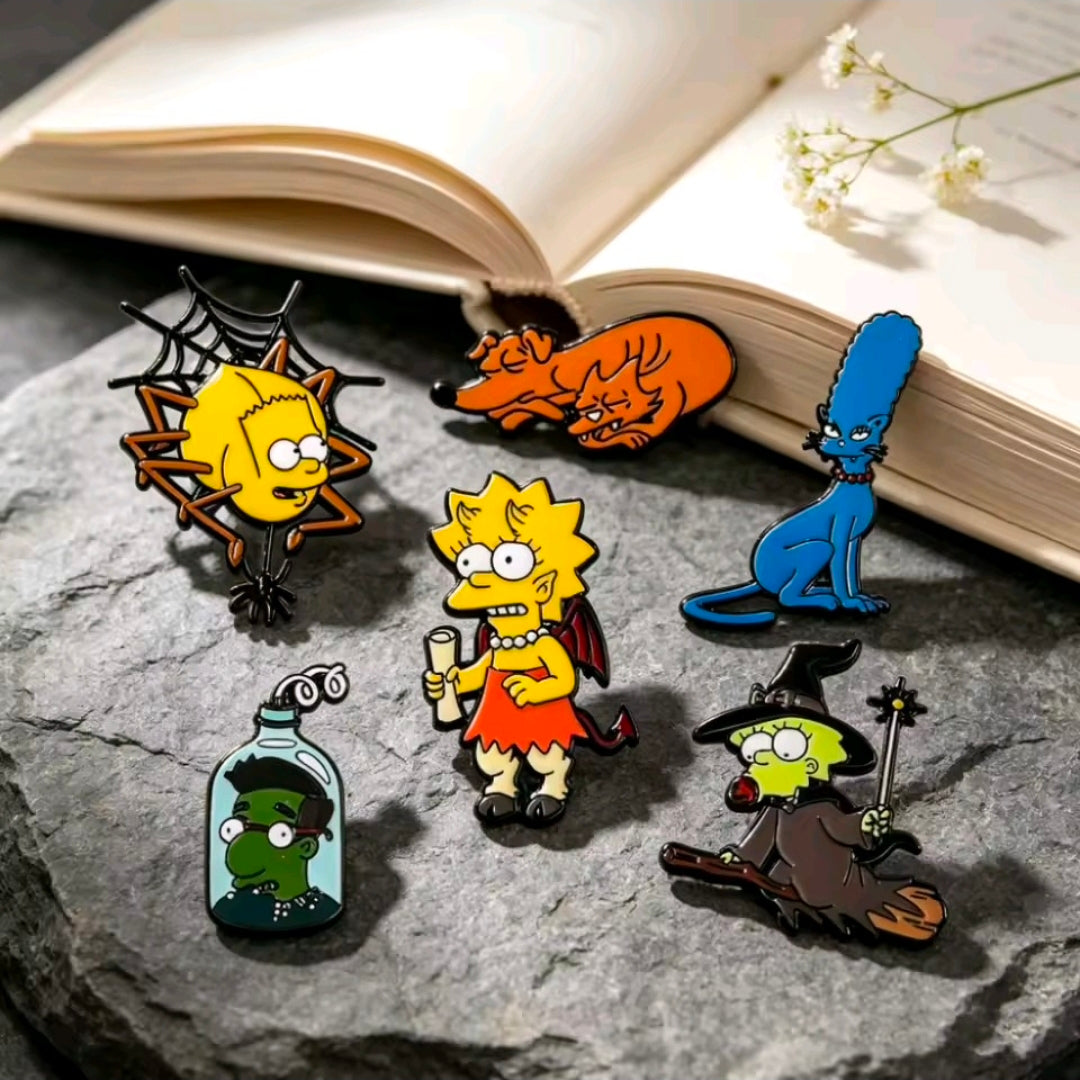 Six colorful Halloween character enamel pins arranged on stone near an open book
