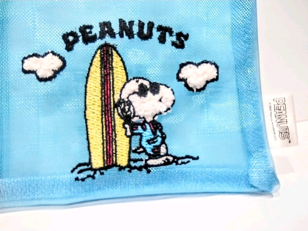 Close-up of blue Peanuts Snoopy surfboard zipper pouch with “PEANUTS” text