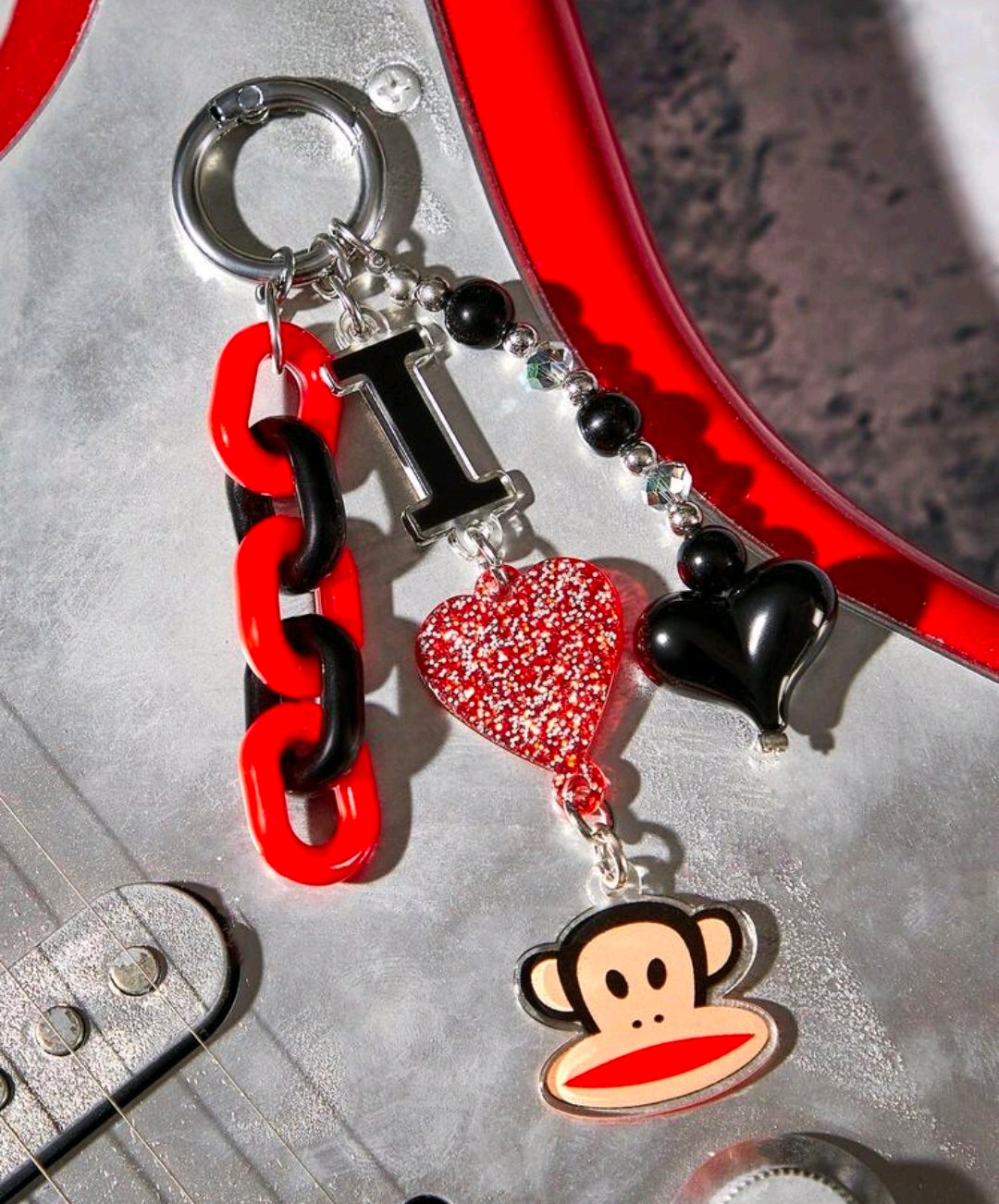 Red and black chain keychain with glitter heart, black heart, and monkey charms