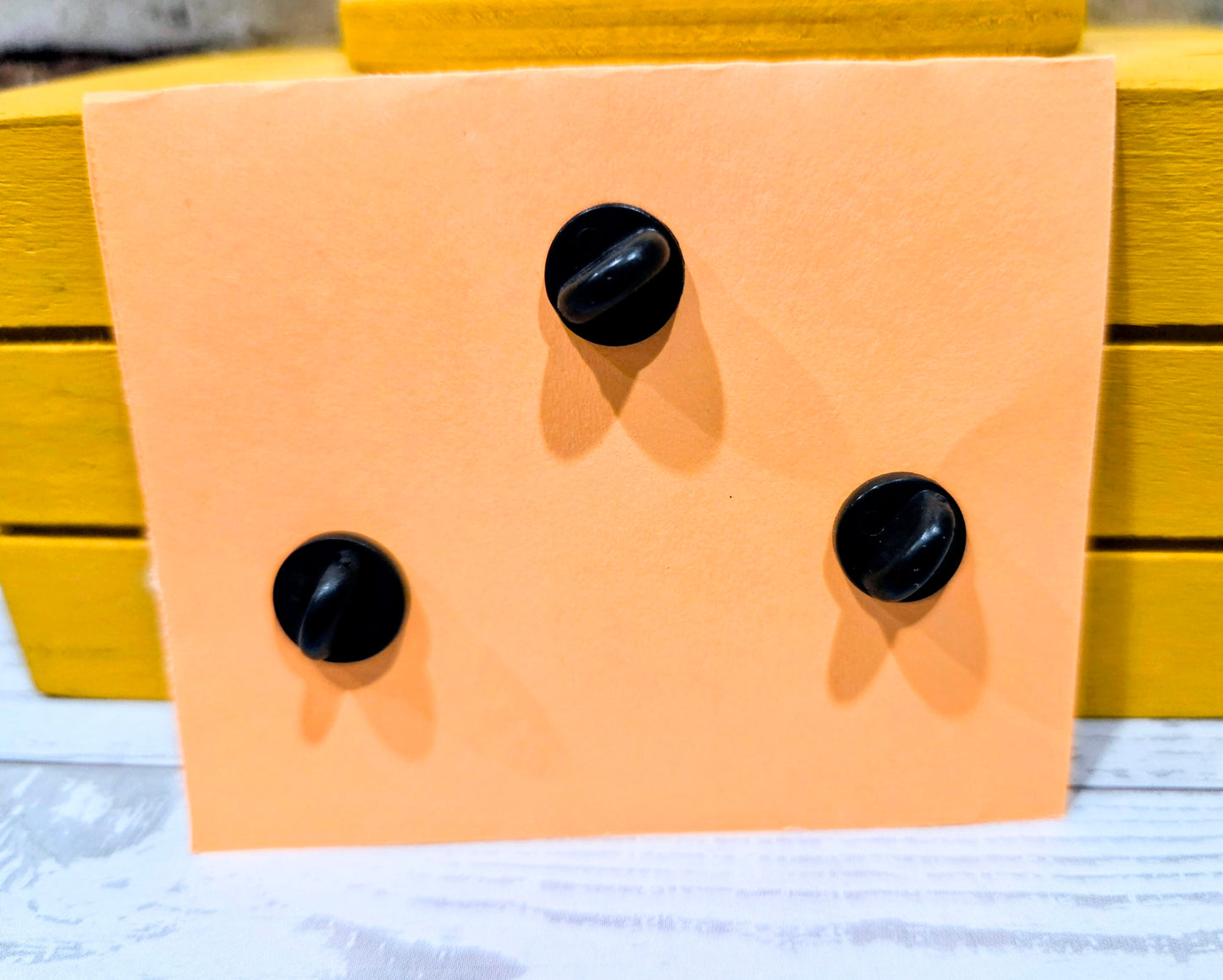 Enamel pin backs with black posts on display card
