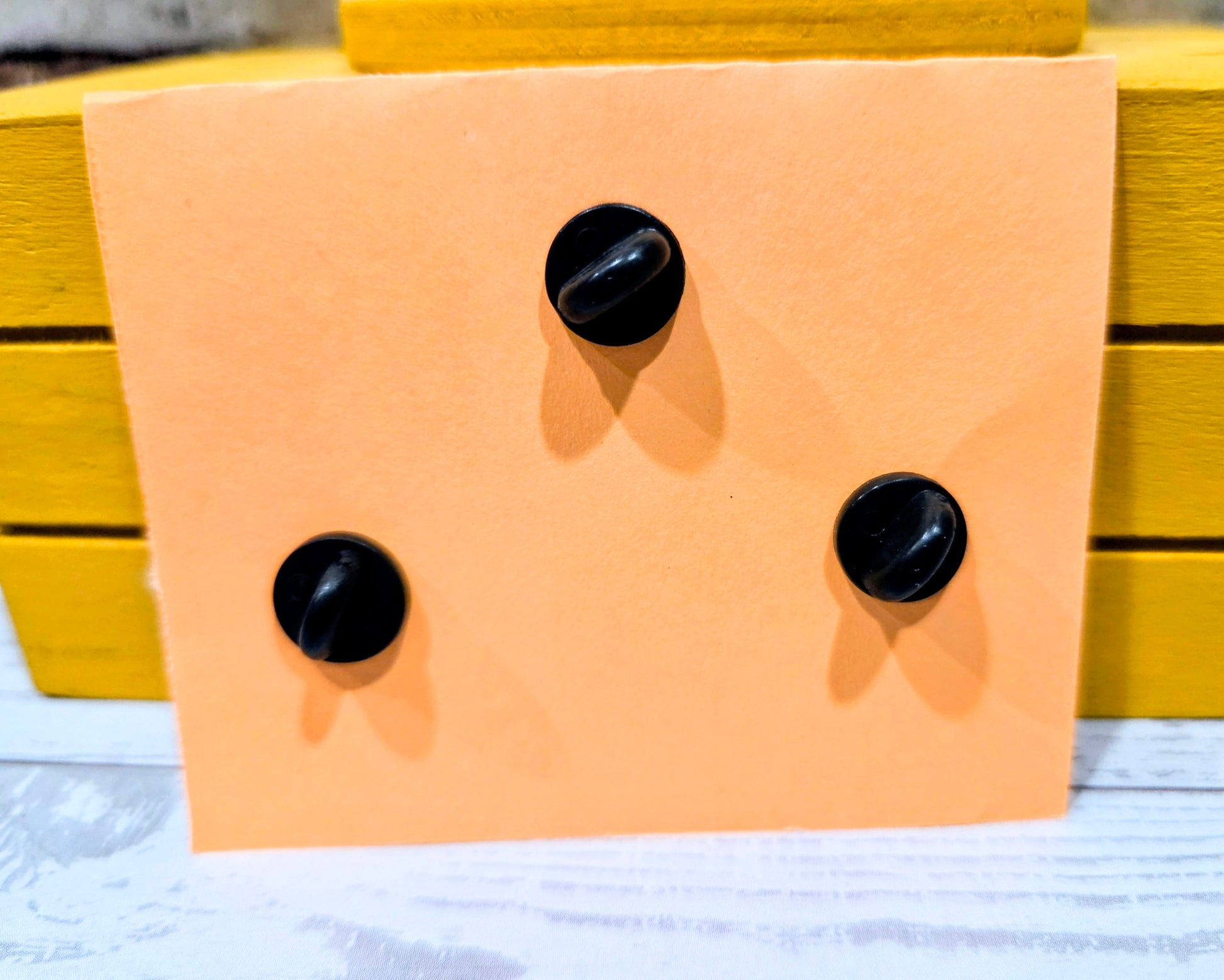 Enamel pin backs with black posts on display card