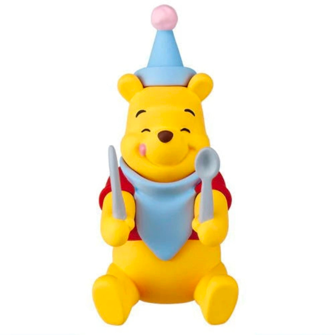 Winnie the Pooh character figure holding two gray utensils with blue scarf and purple cap