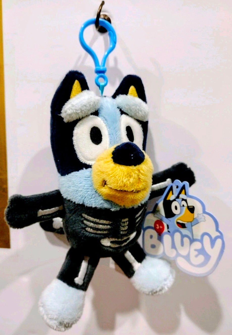 Blue and black Halloween plush keychain with yellow nose and ribcage pattern, tag visible