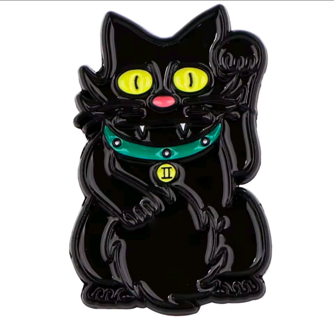 Black cat enamel pin close-up with yellow eyes, pink nose, and teal scarf
