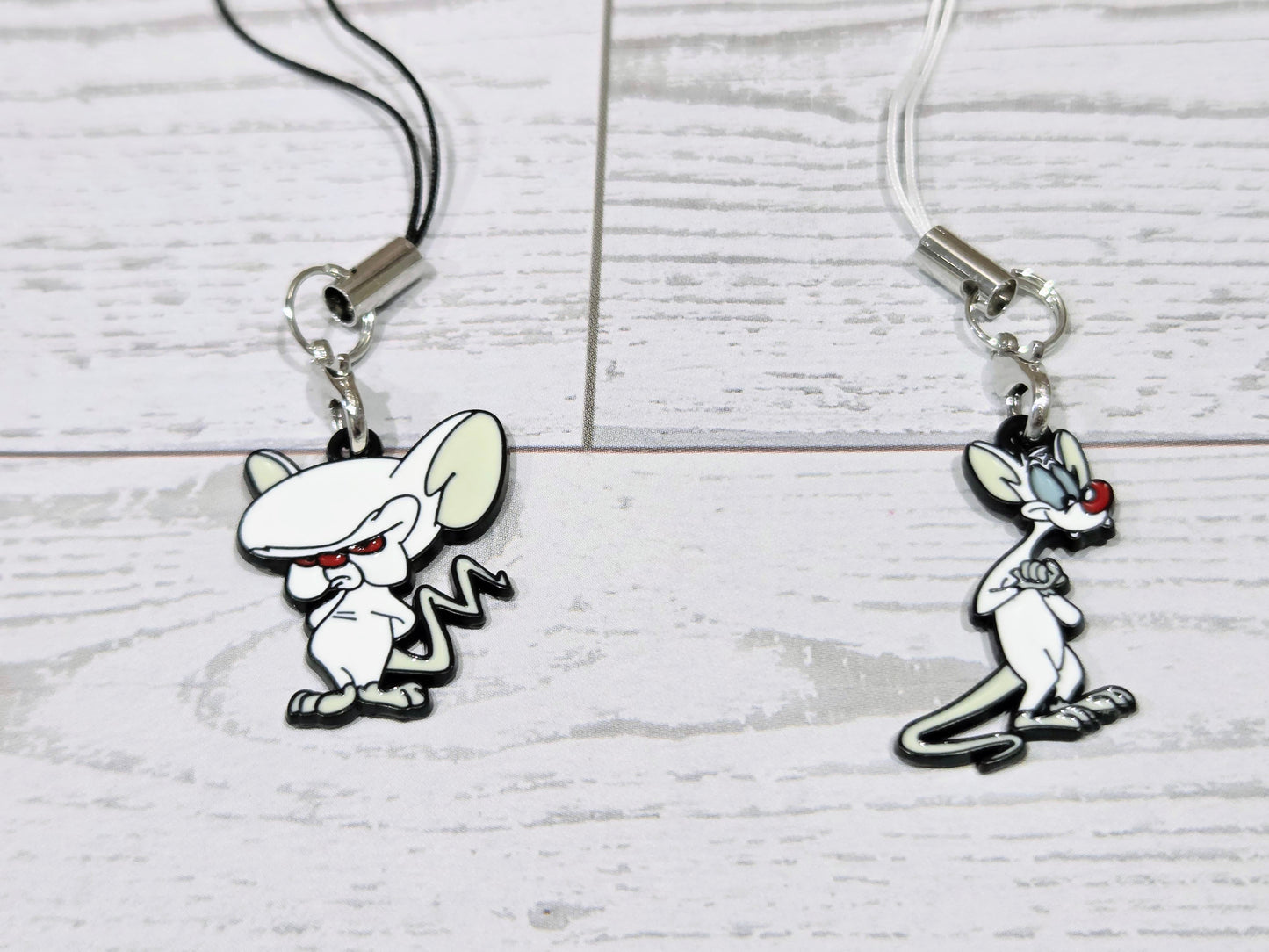 Two cartoon mouse phone keychain charms with silver clips and black cords