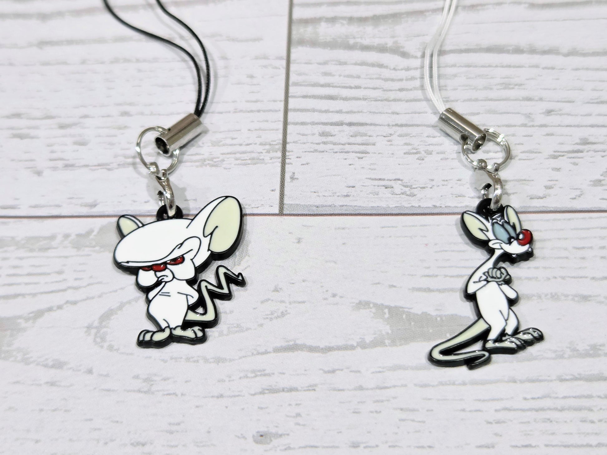 Two cartoon mouse phone keychain charms with silver clips and black cords
