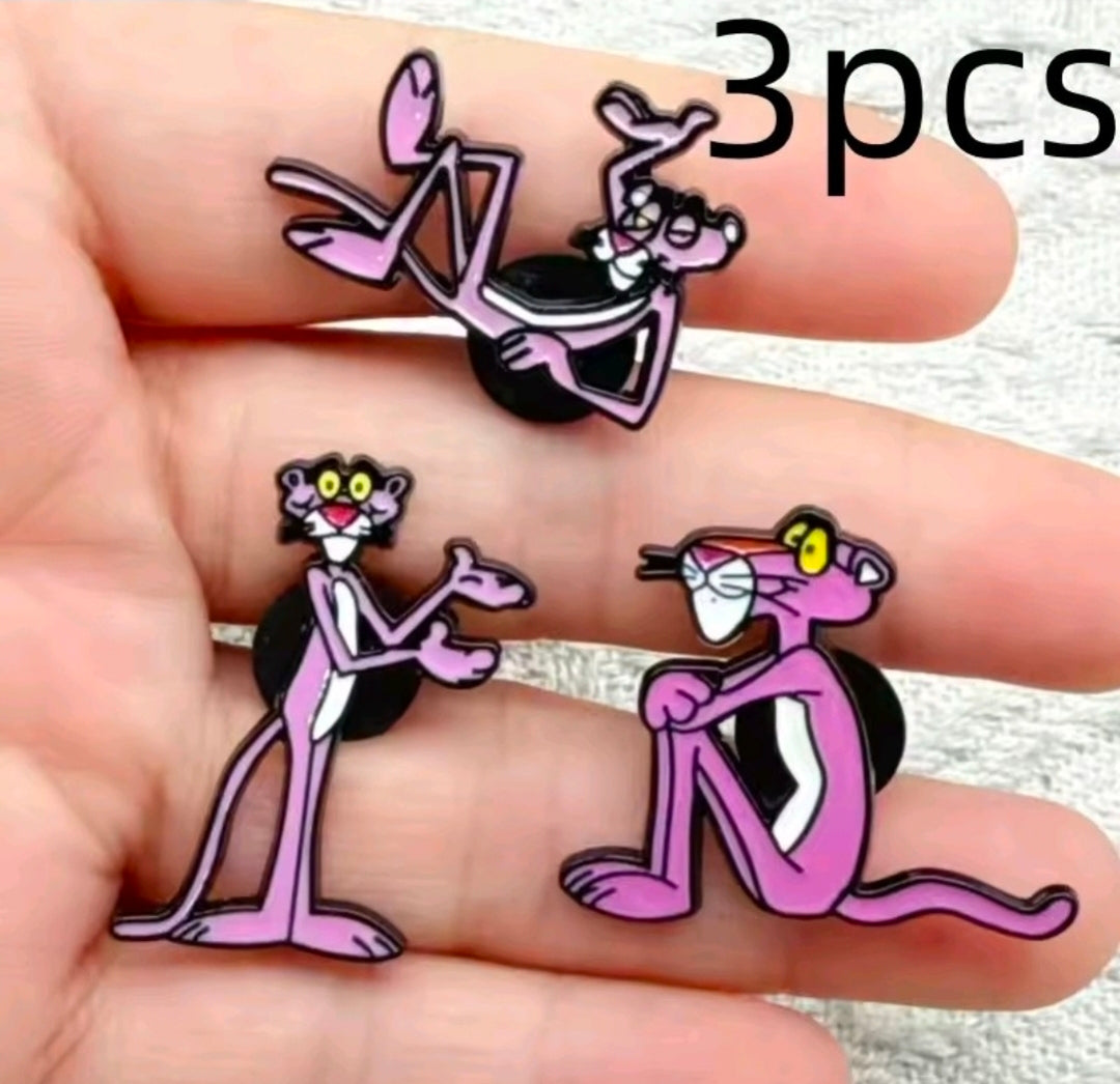 Enamel character pins on hand: three pink-and-black cat pins