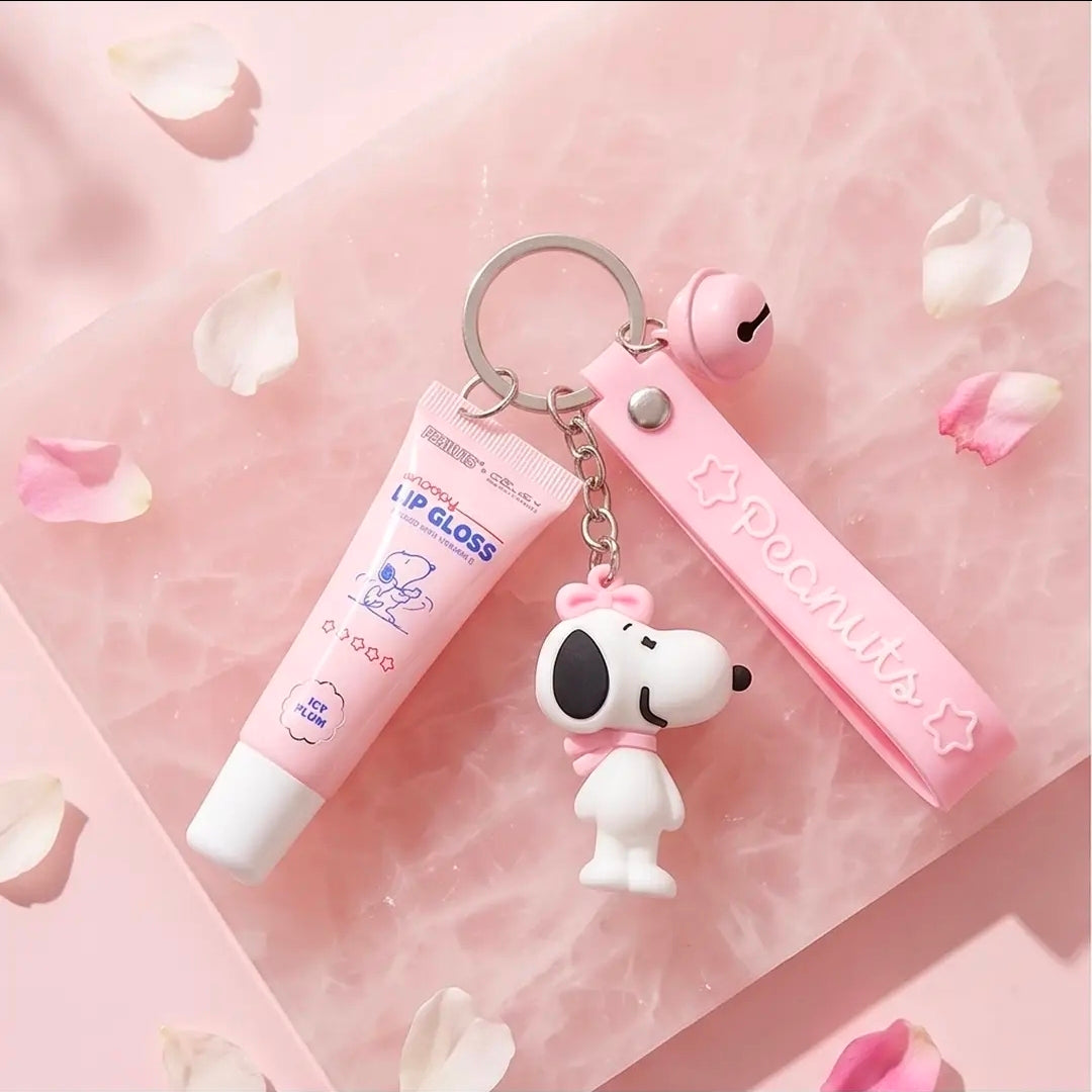 Peanuts-themed lip gloss keychain set with pink strap, Snoopy charm, and lip gloss tube