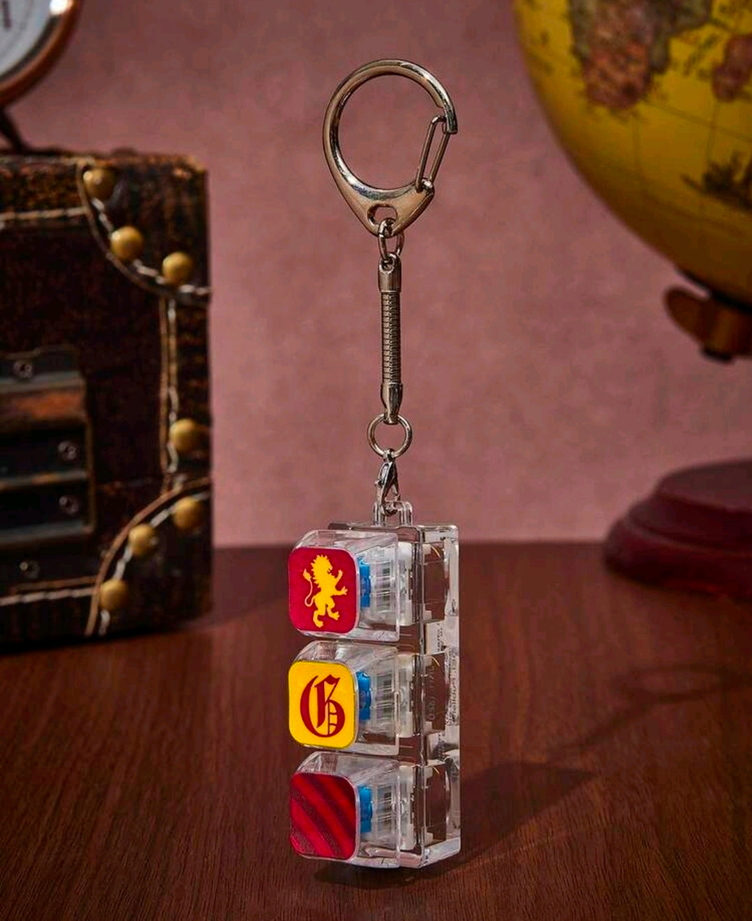 Keychain fidget charm with silver spring and three clear keycaps featuring lion, crest, stripes
