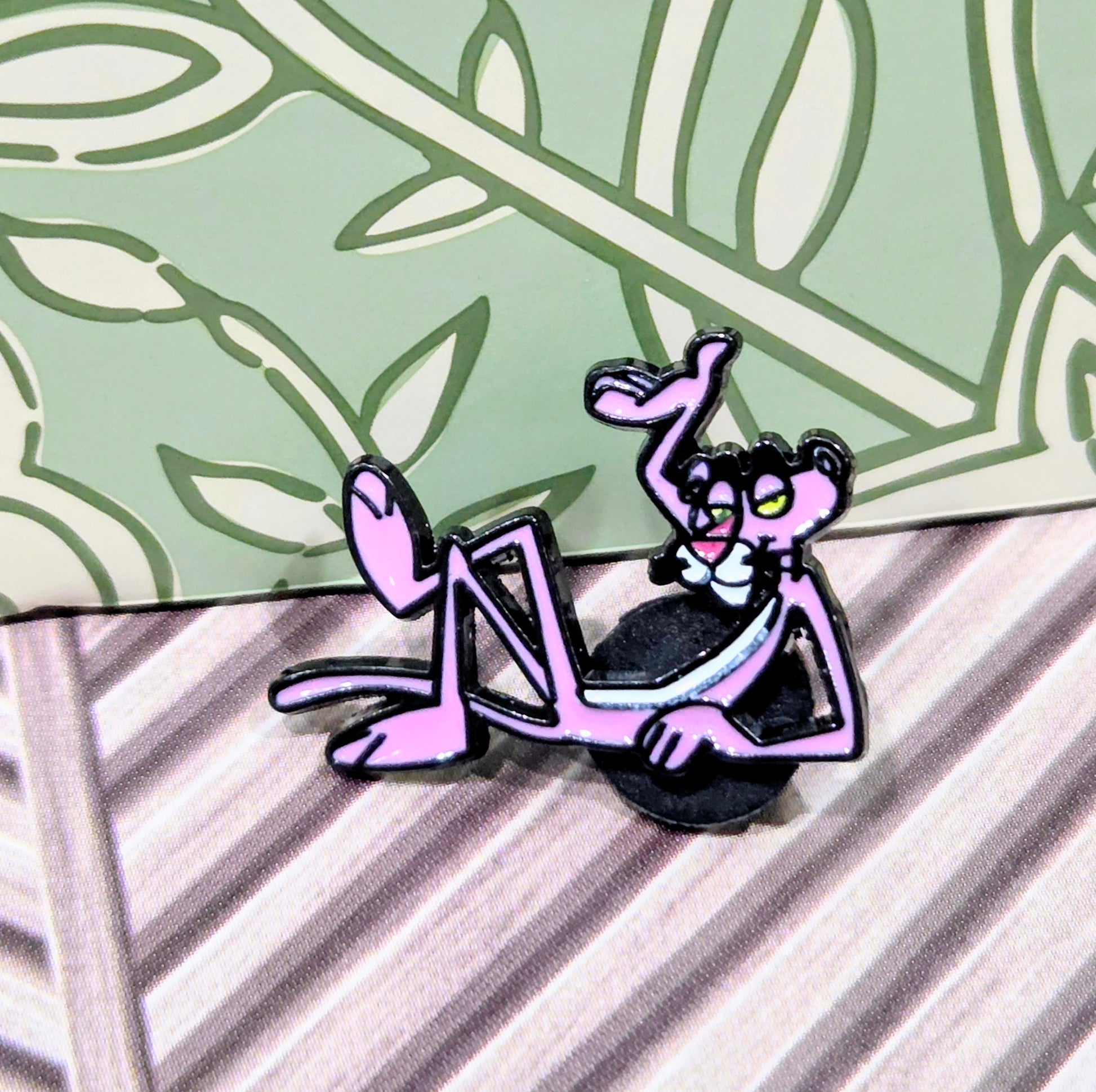 Two enamel cat character pins in pink and black, seated and standing poses